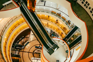 Interior view of a modern shopping mall with escalators.