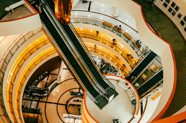 Interior view of a modern shopping mall with escalators.