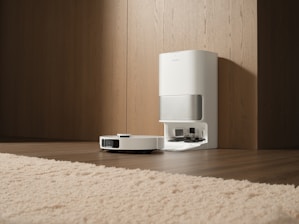 White robot vacuum cleaner docked at charging station.