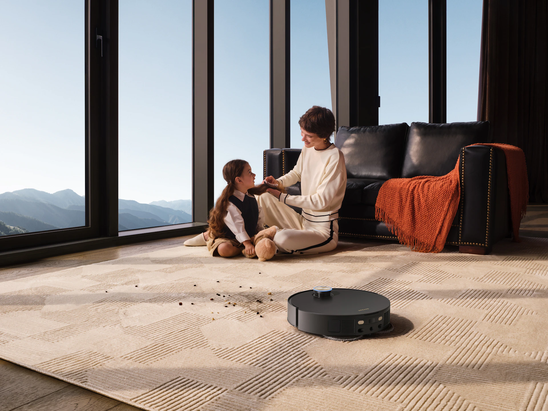 Mother and child watching robot vacuum clean floor