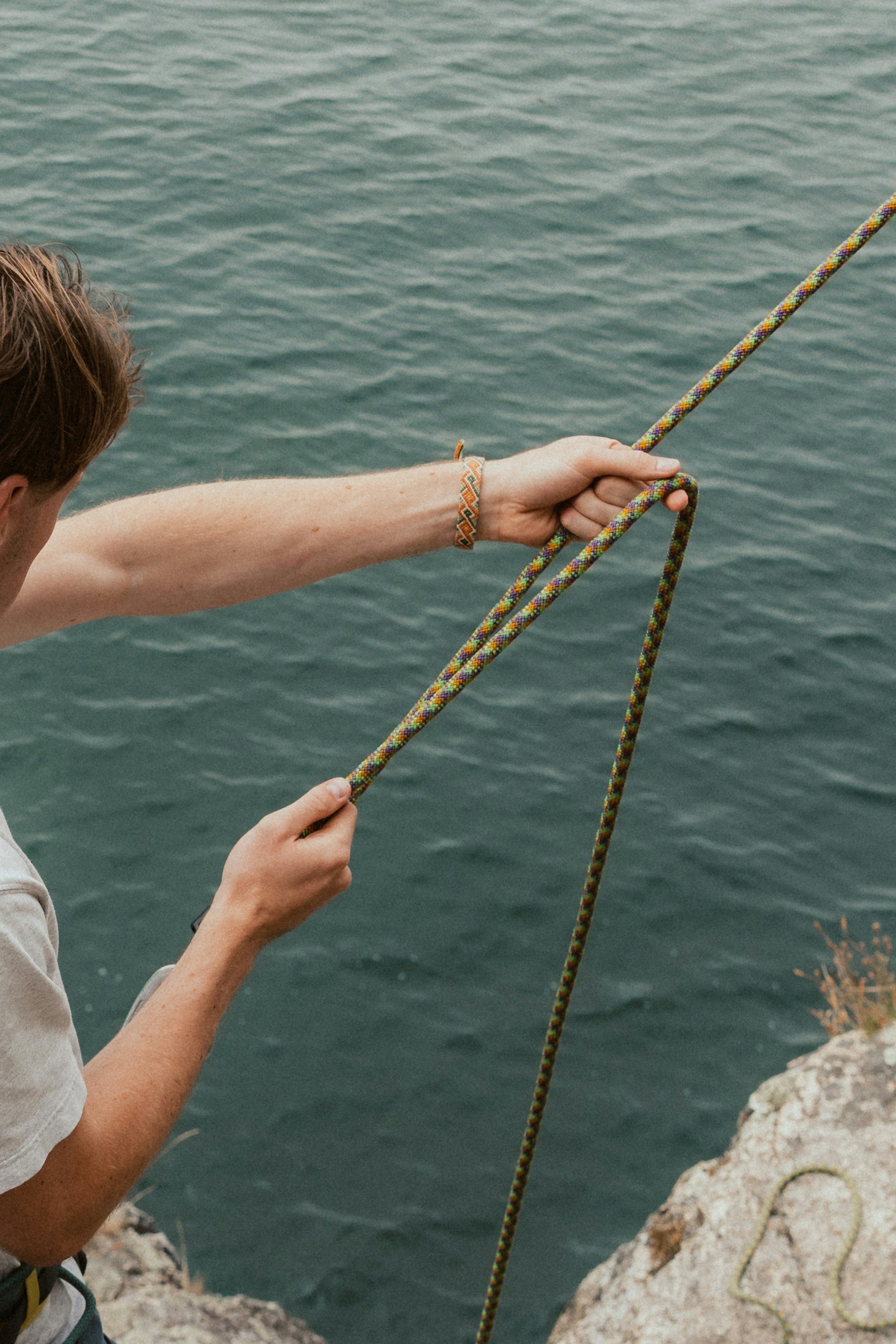 Hombre sosteniendo una cuerda cerca del océano