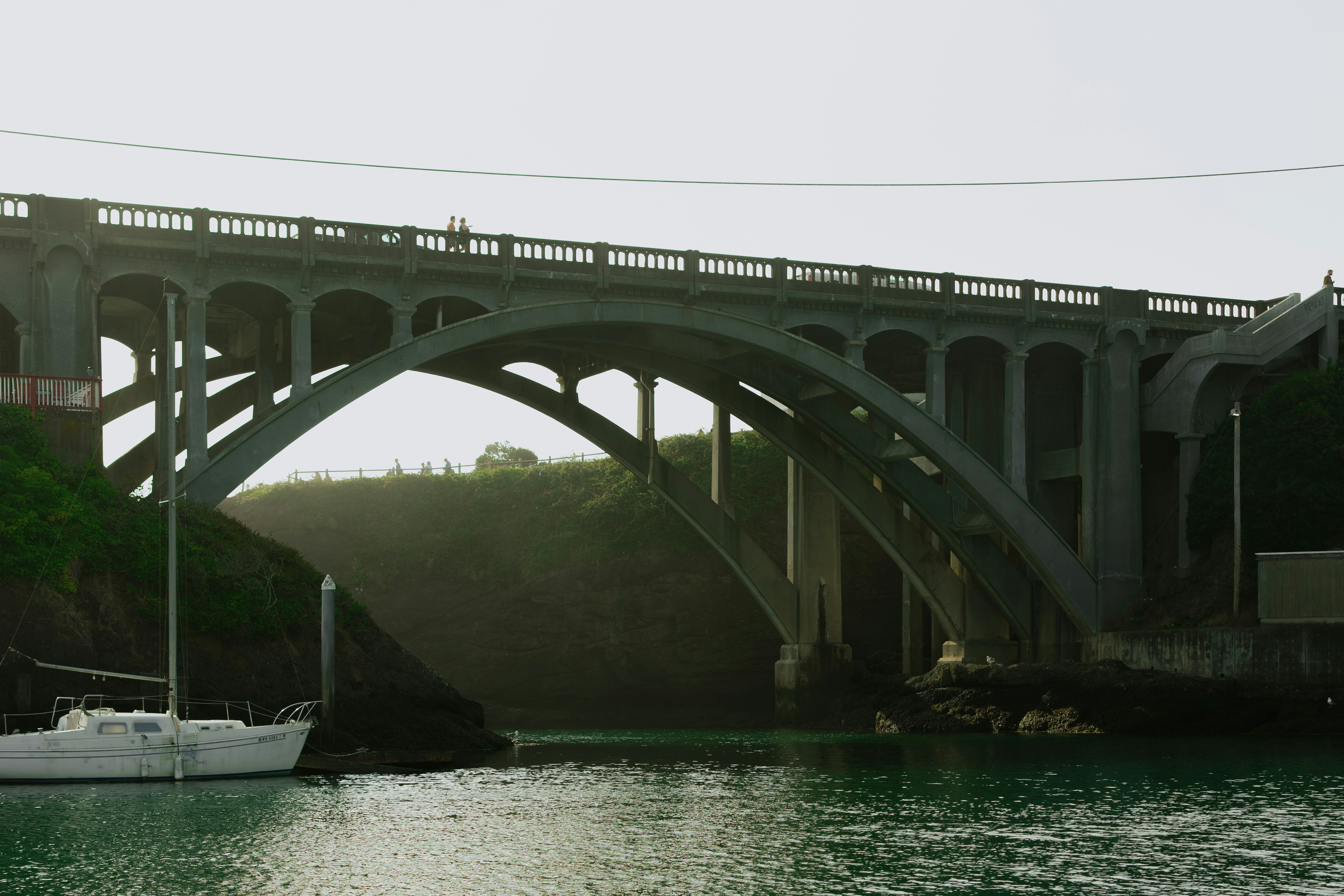 A large concrete bridge arches over a body of water.