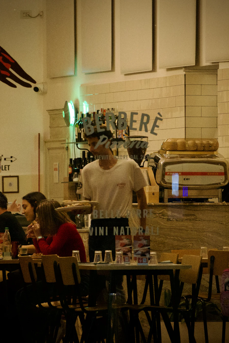 A waiter serving customers in a busy restaurant