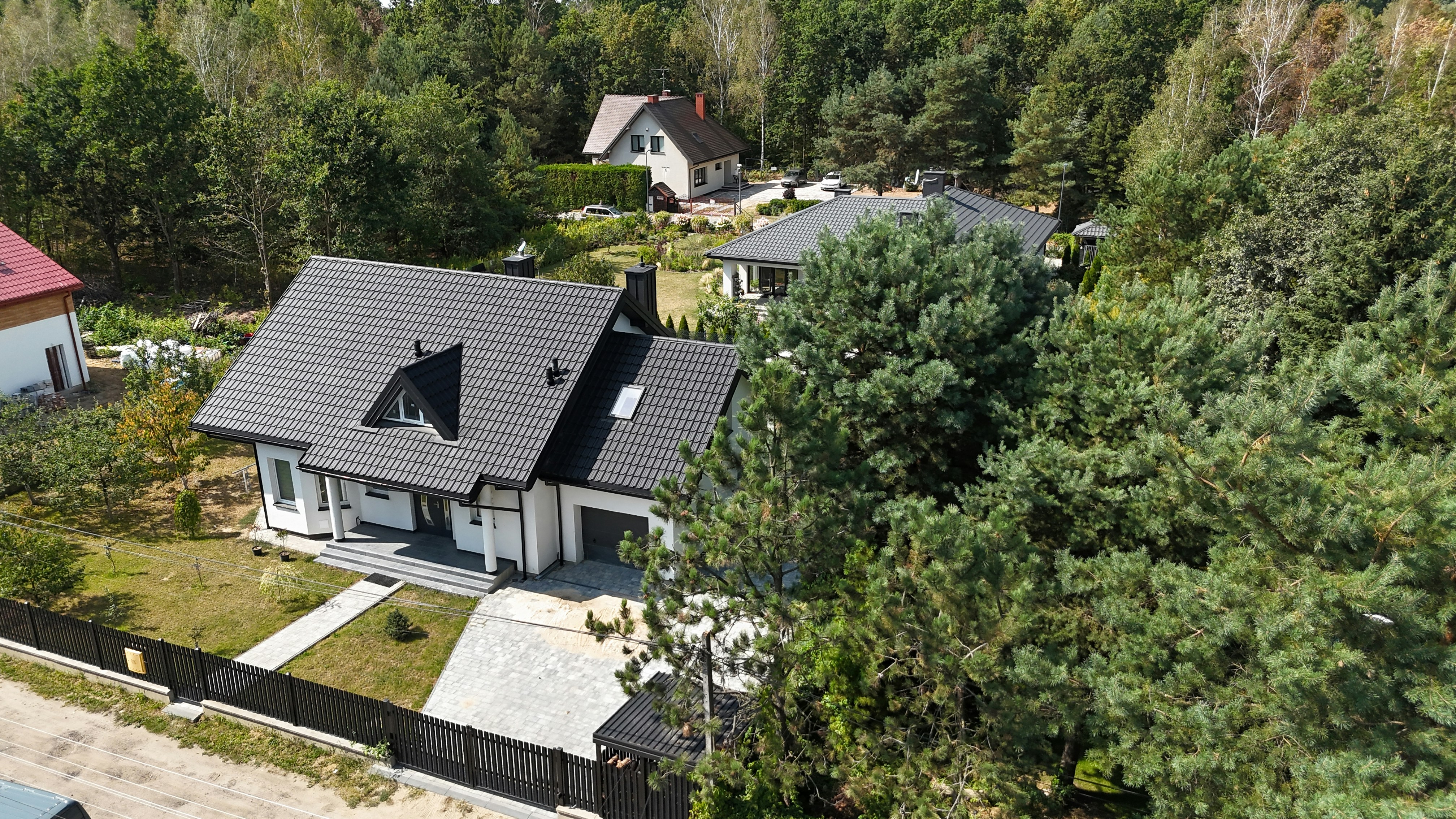 Modern house surrounded by lush green trees.