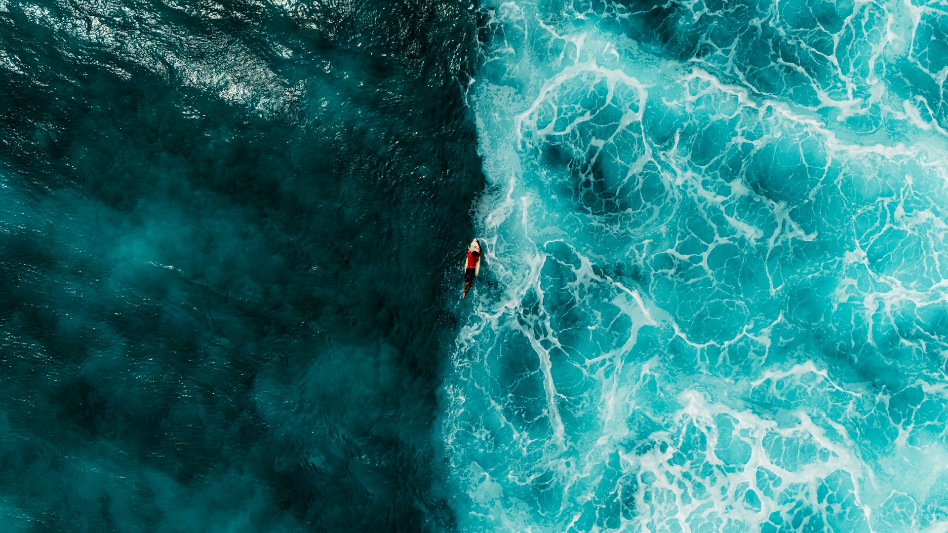Surfer rides a large wave from above