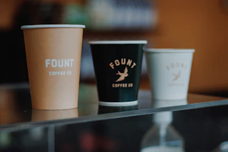 Three coffee cups with fount coffee co. branding.
