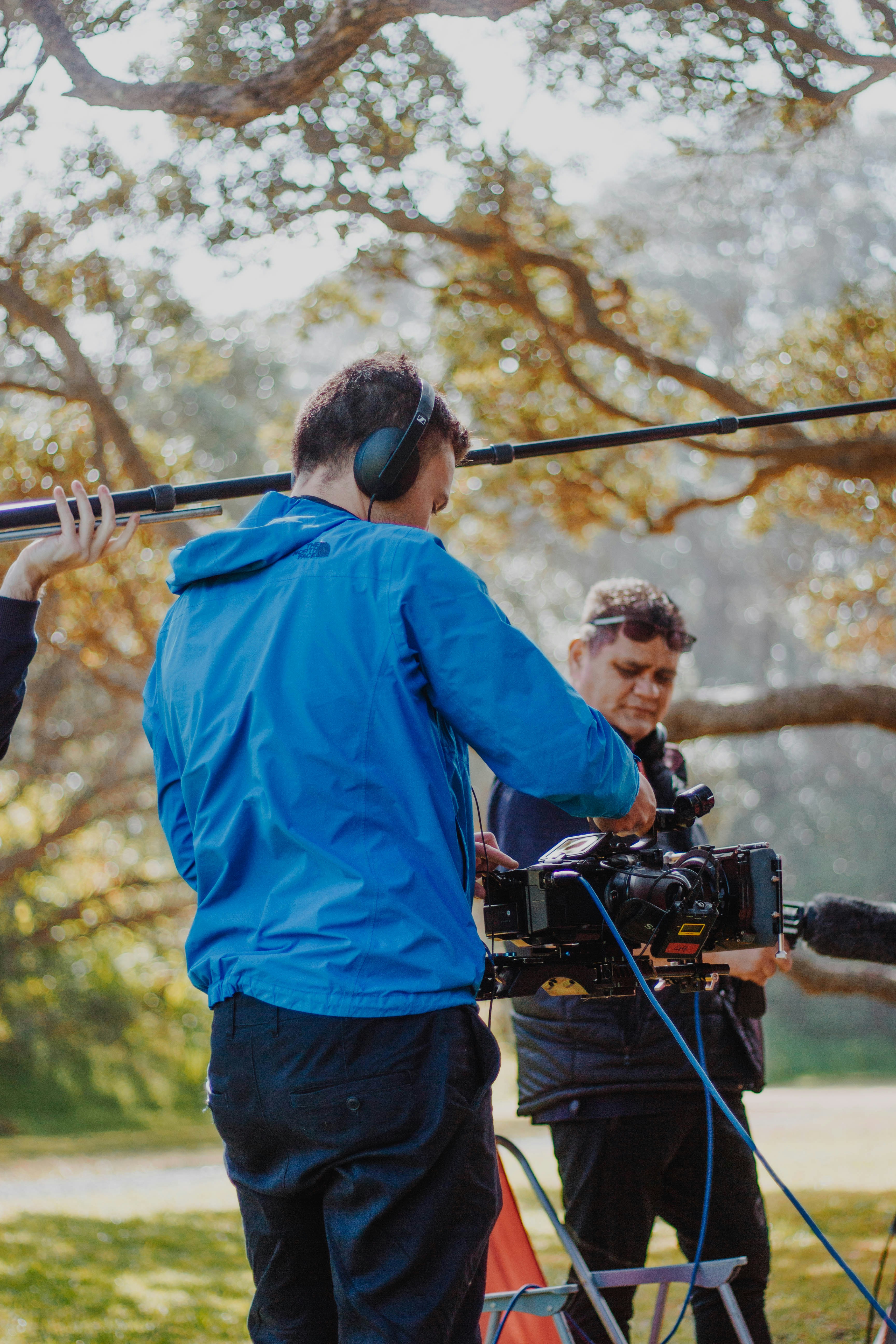 Filmmakers operating camera and boom mic outdoors