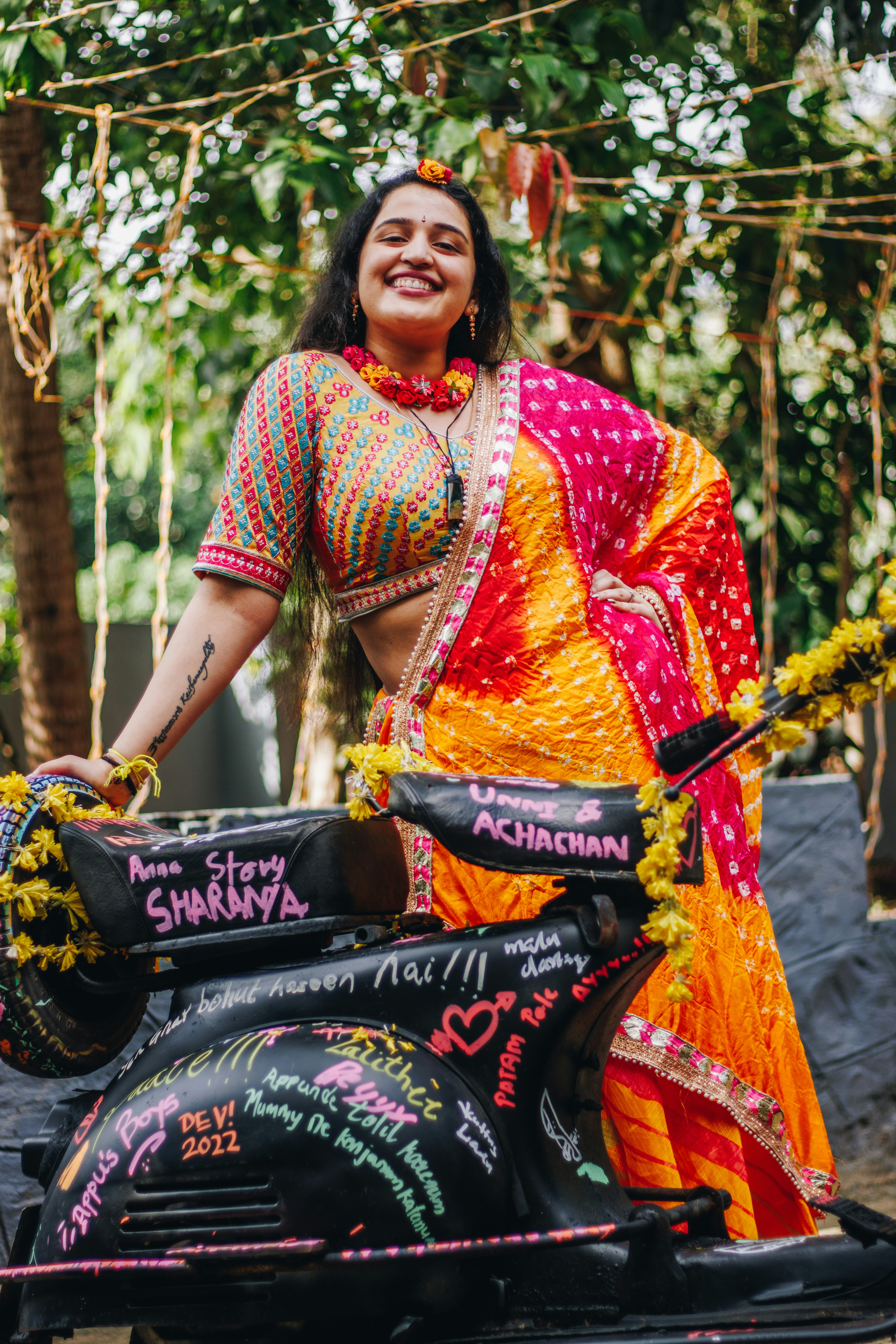 Woman in colorful sari posing on decorated scooter