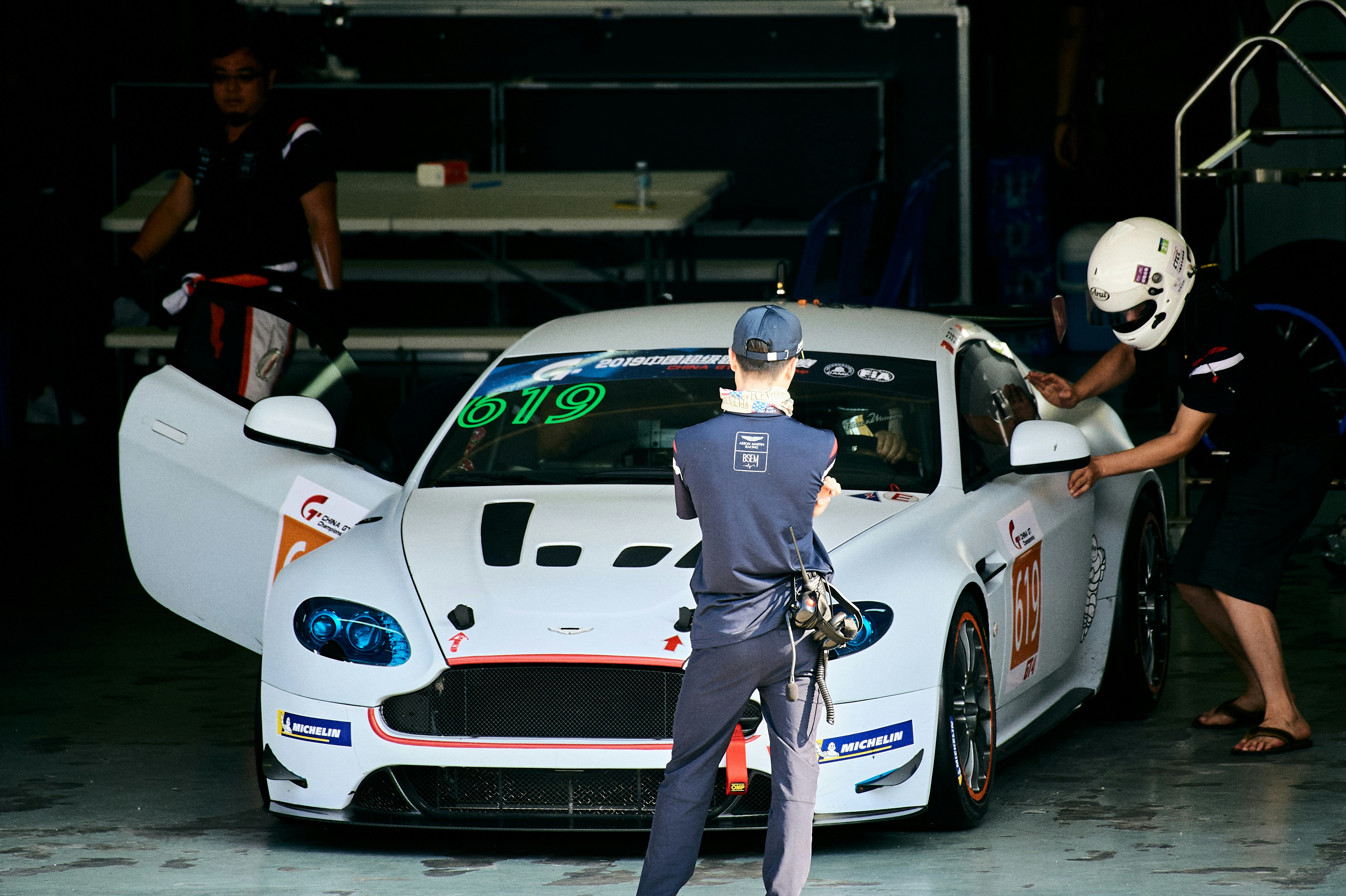 Race car crew works on a white sports car.
