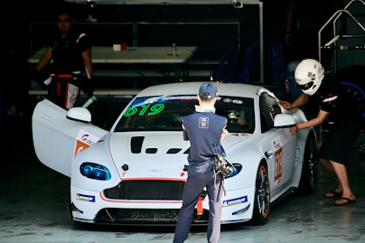 Race car crew works on a white sports car.