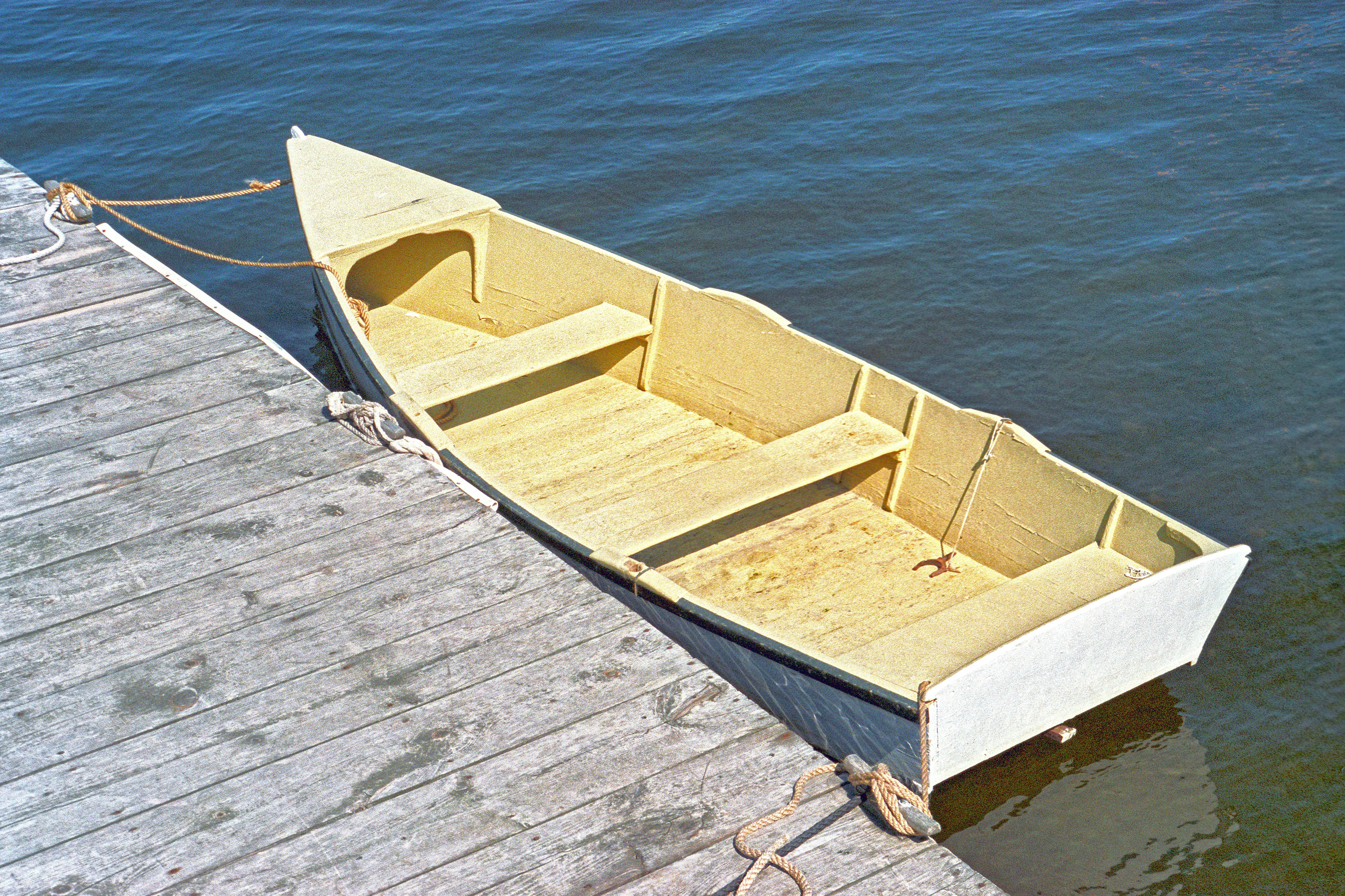 A wooden rowboat tied to a dock