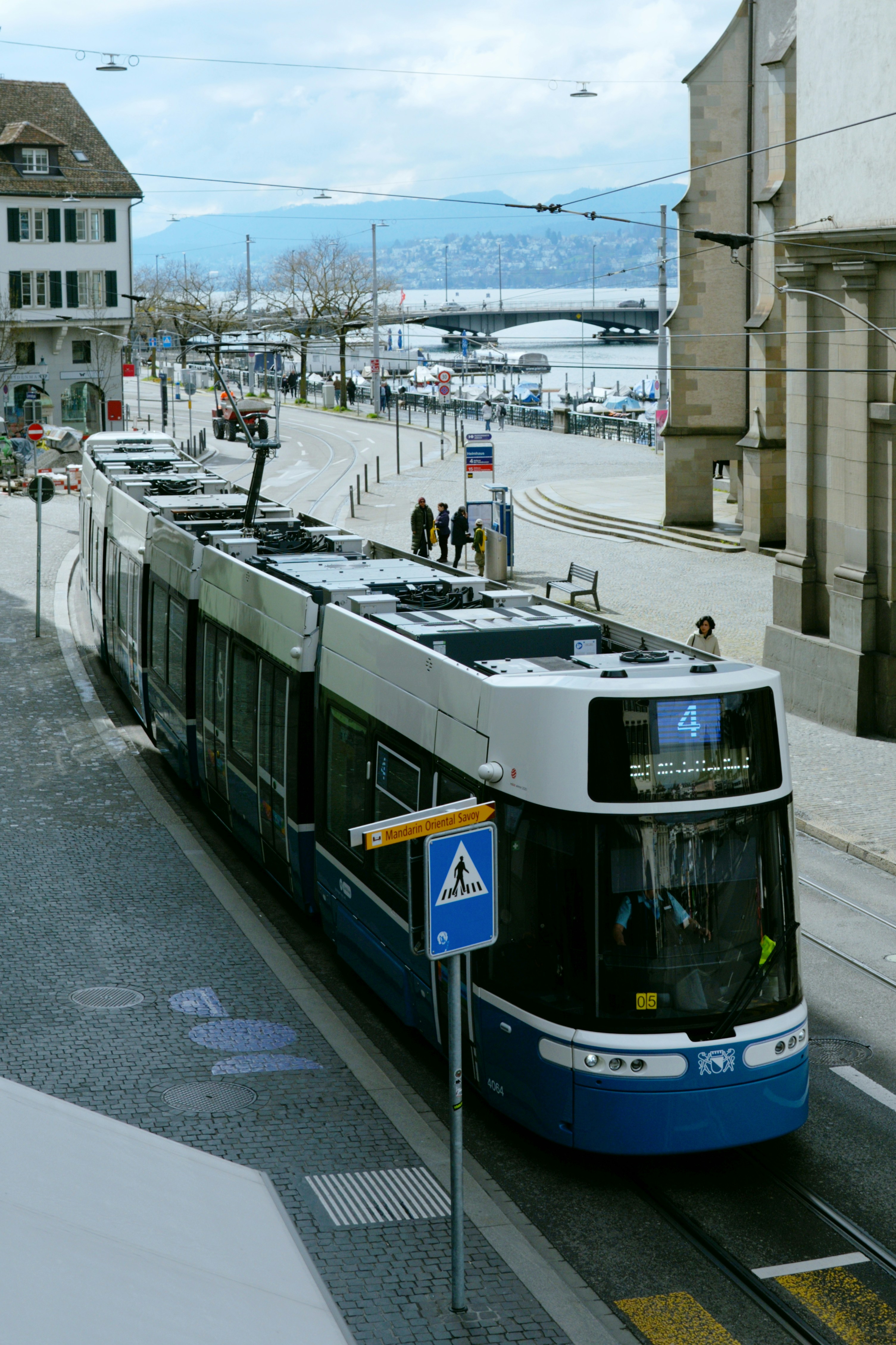 A blue and white tram on a city street