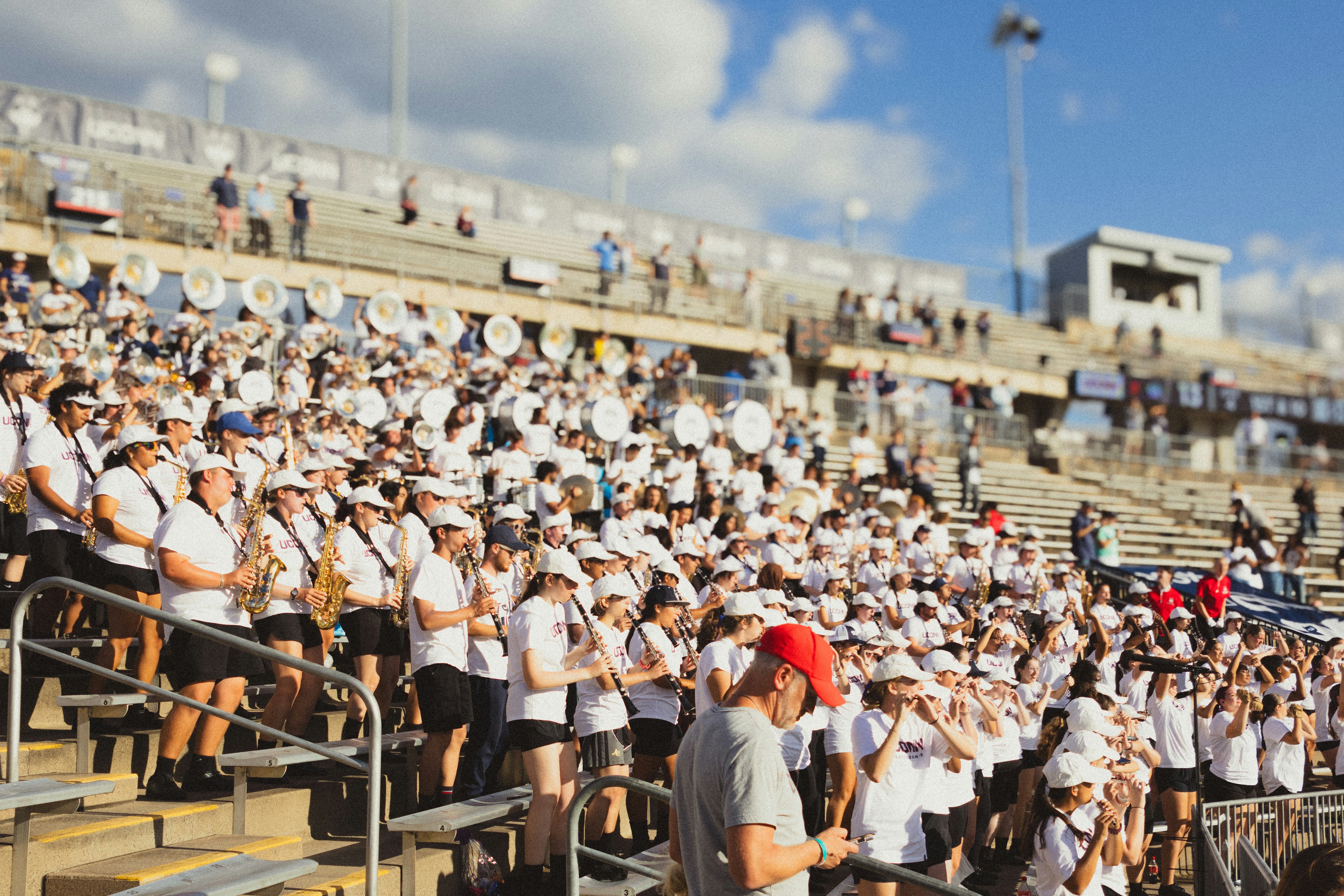 A marching band in uniform in stadium bleachers