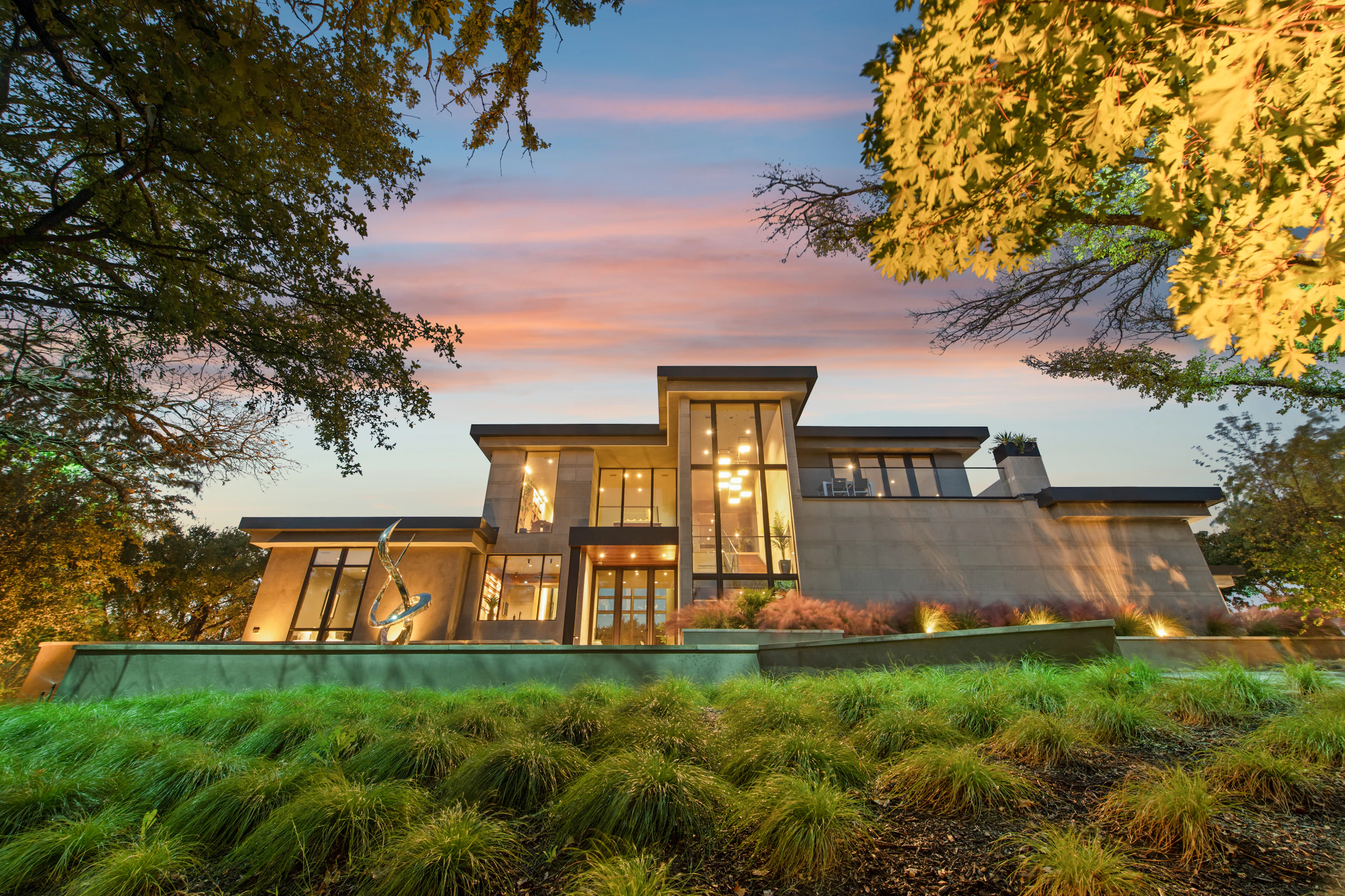 Modern home with large windows lit up at dusk
