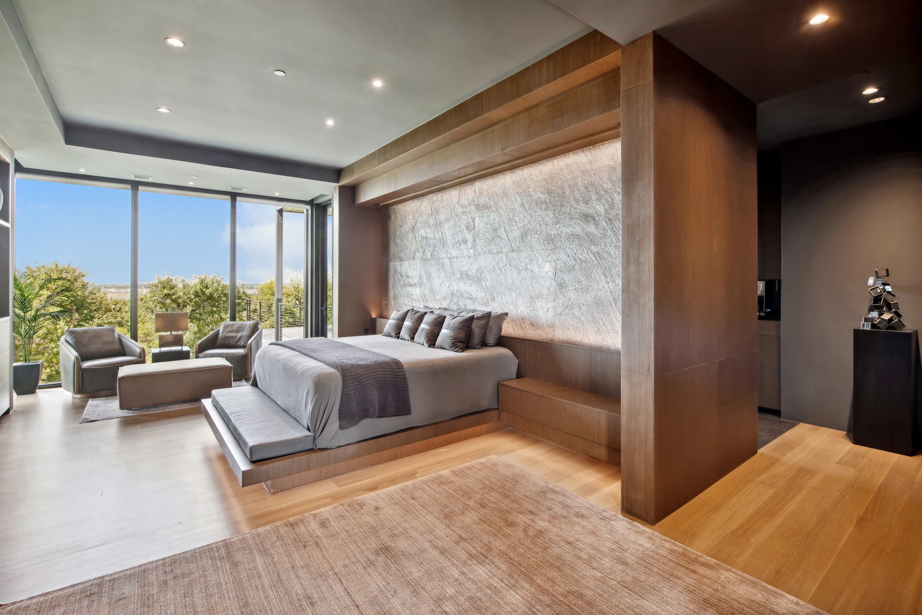 Quarto moderno com cama baixa, madeira natural e janelas amplas