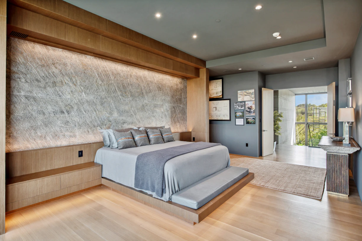 Modern bedroom with a large bed and textured wall.