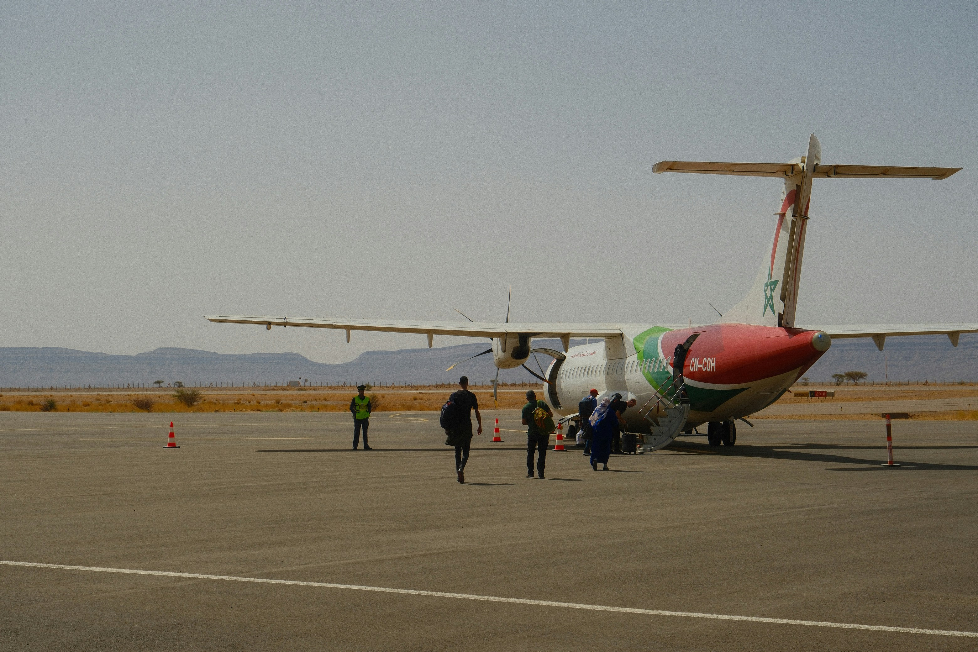 Passengers boarding a small airplane on a sunny day.