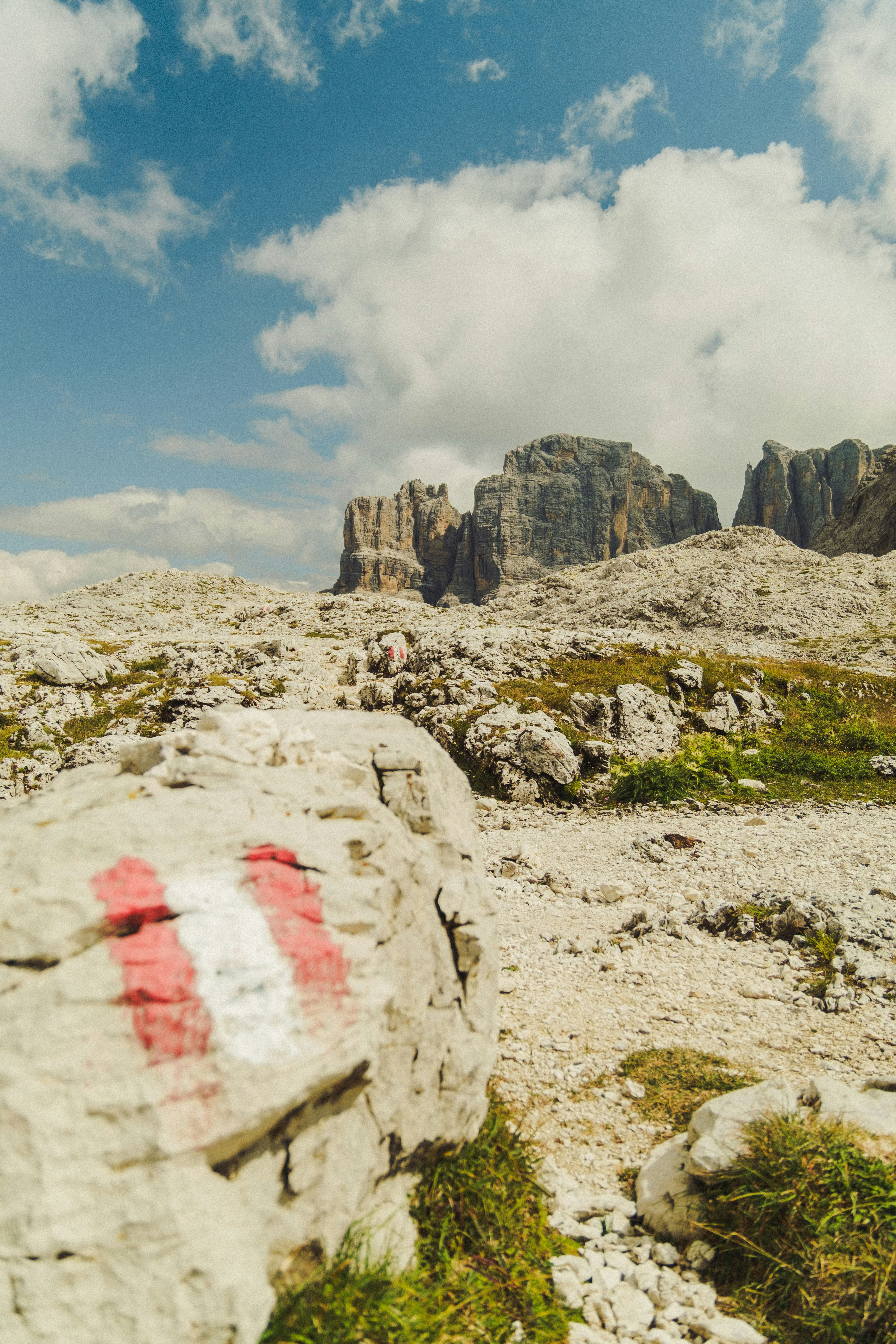 Segnavia di montagna su terreno roccioso con cime lontane