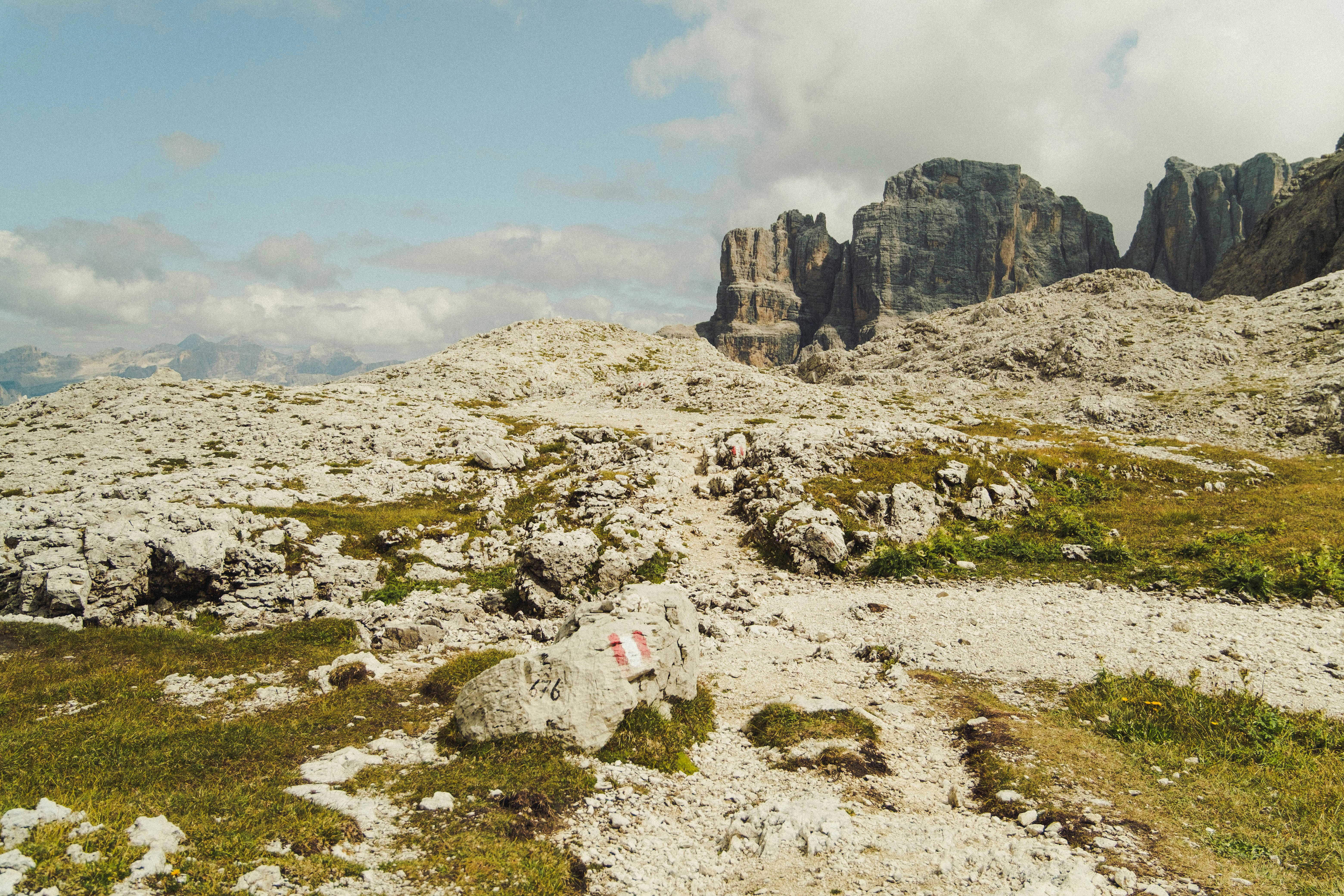Sentiero di montagna roccioso con cime frastagliate in lontananza