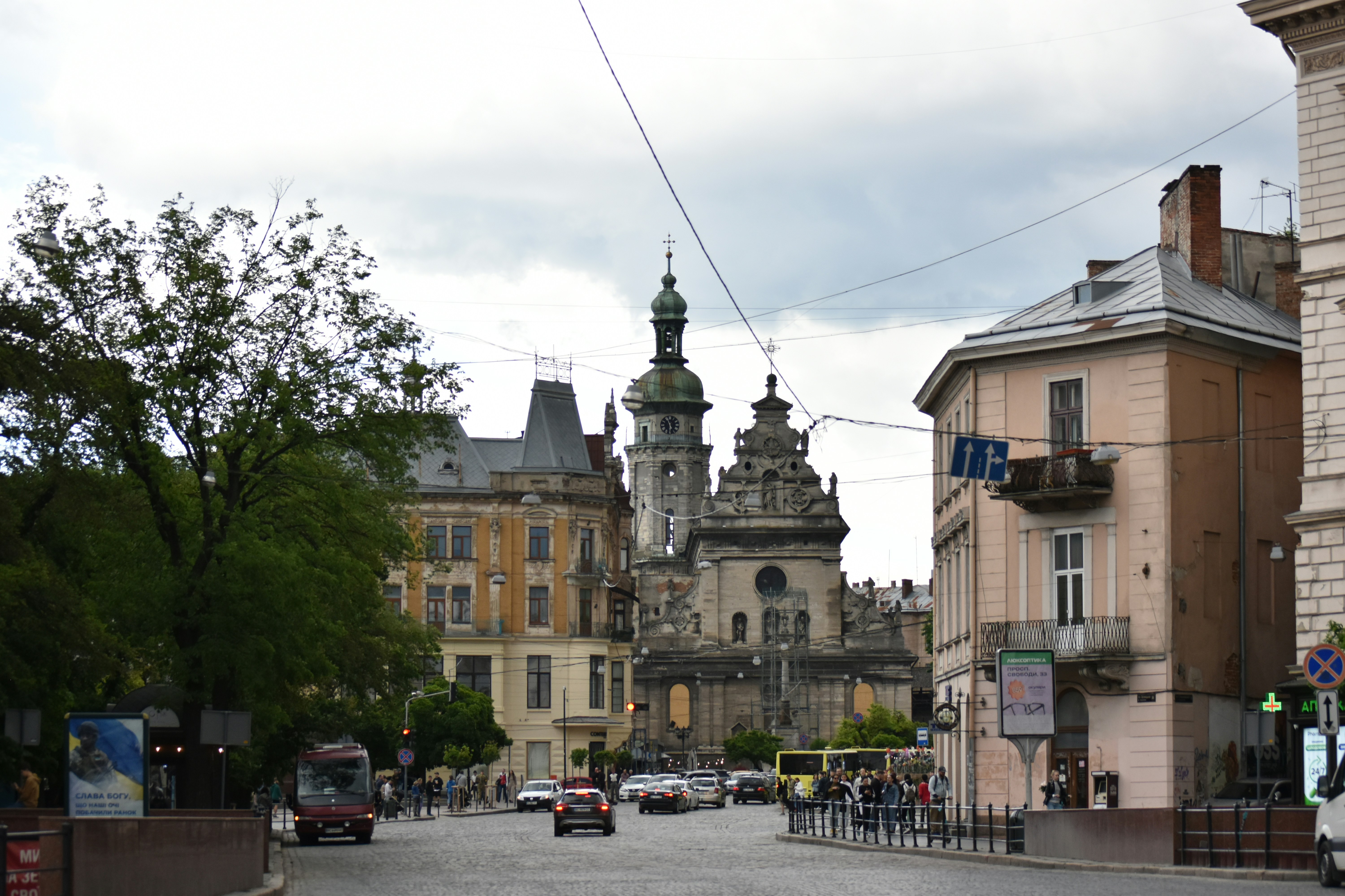 City square with historic buildings and traffic.