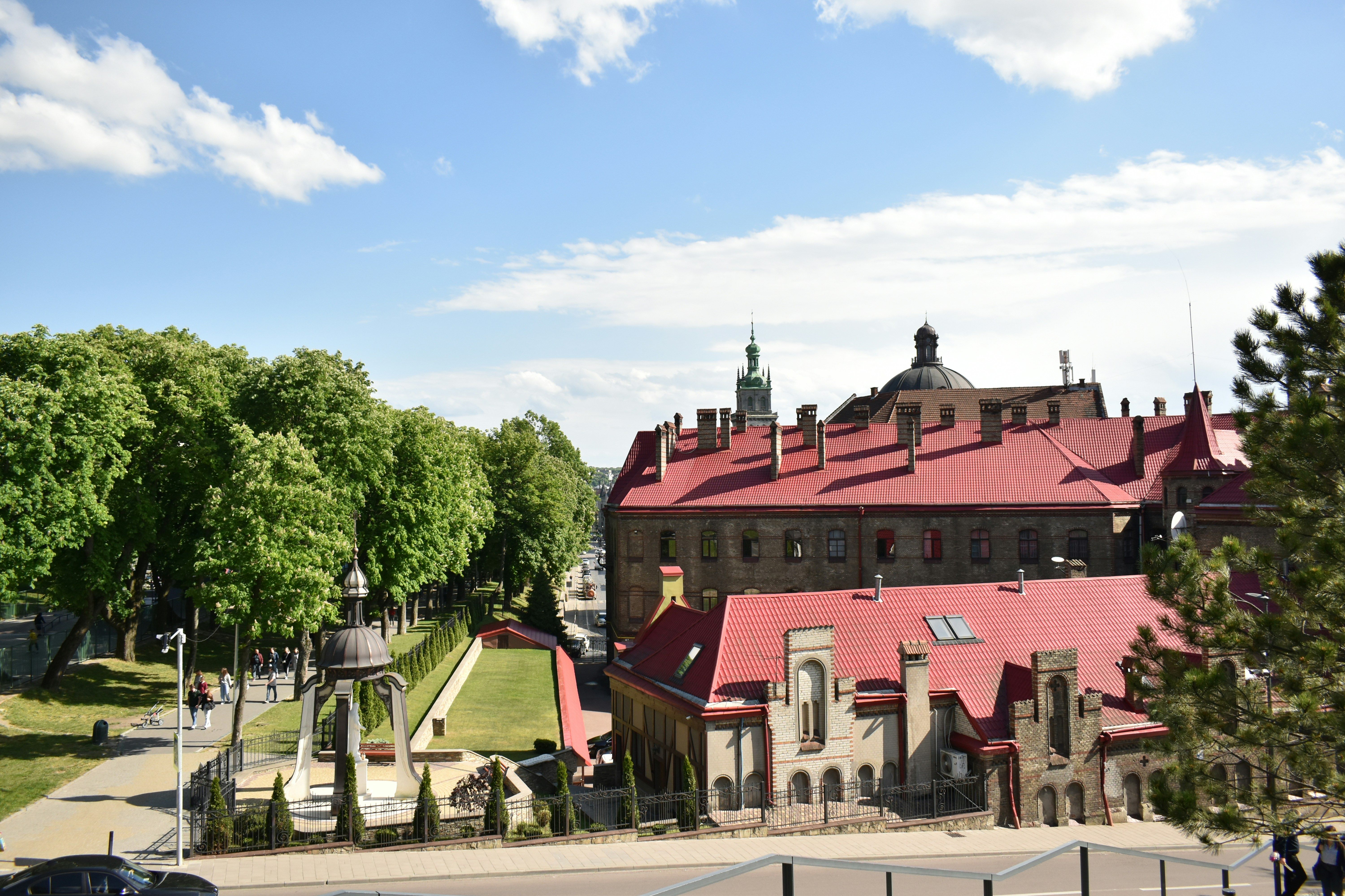 Large building with red roof and green trees