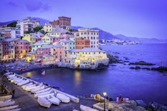 Colorful buildings line a harbor with boats at dusk.