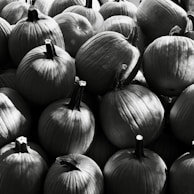 A pile of pumpkins in black and white.