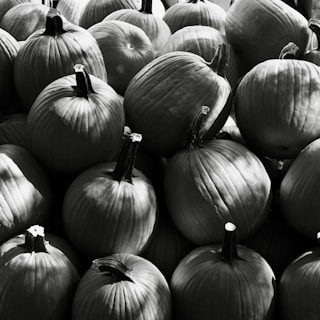 A pile of pumpkins in black and white.
