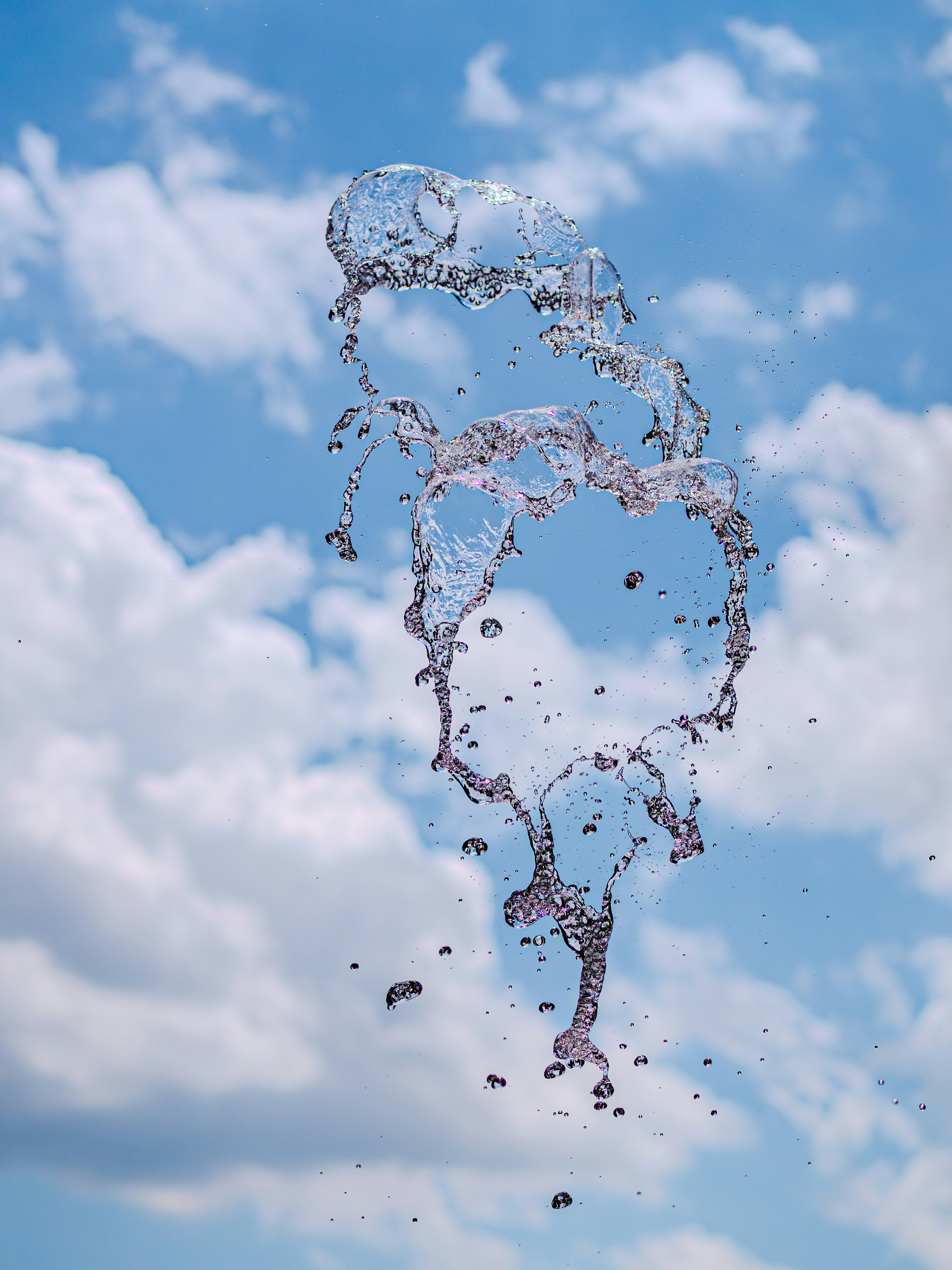 Water splashing against a cloudy blue sky