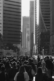 Crowd of people walking on a city street with skyscrapers.