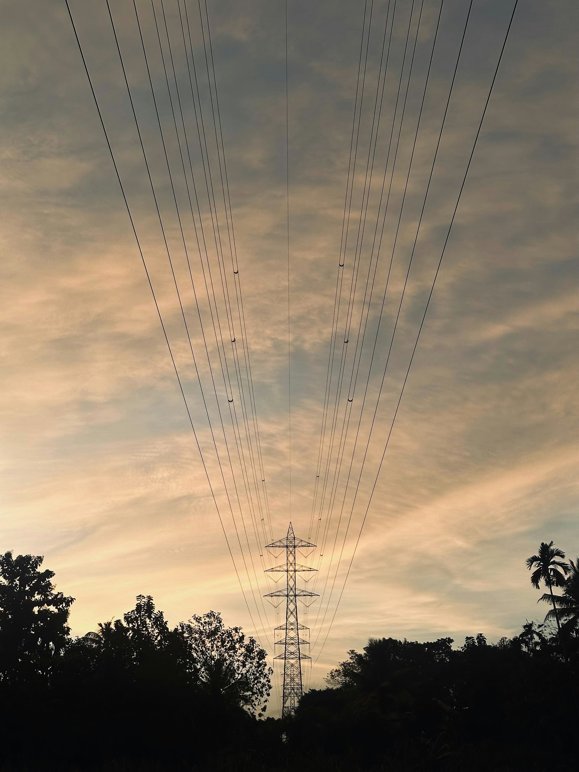 Electrical tower against a dramatic sunset sky.