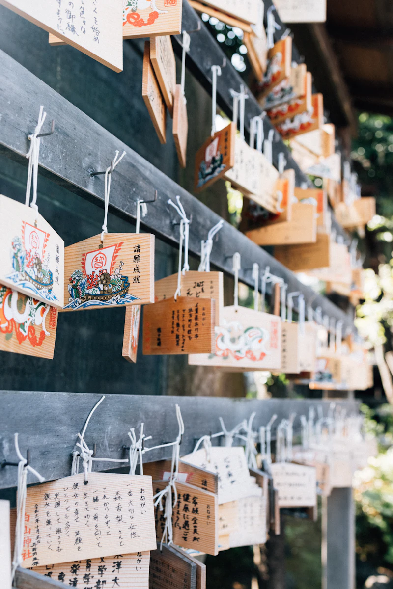 Wooden votive plaques hanging densely on a shrine wall