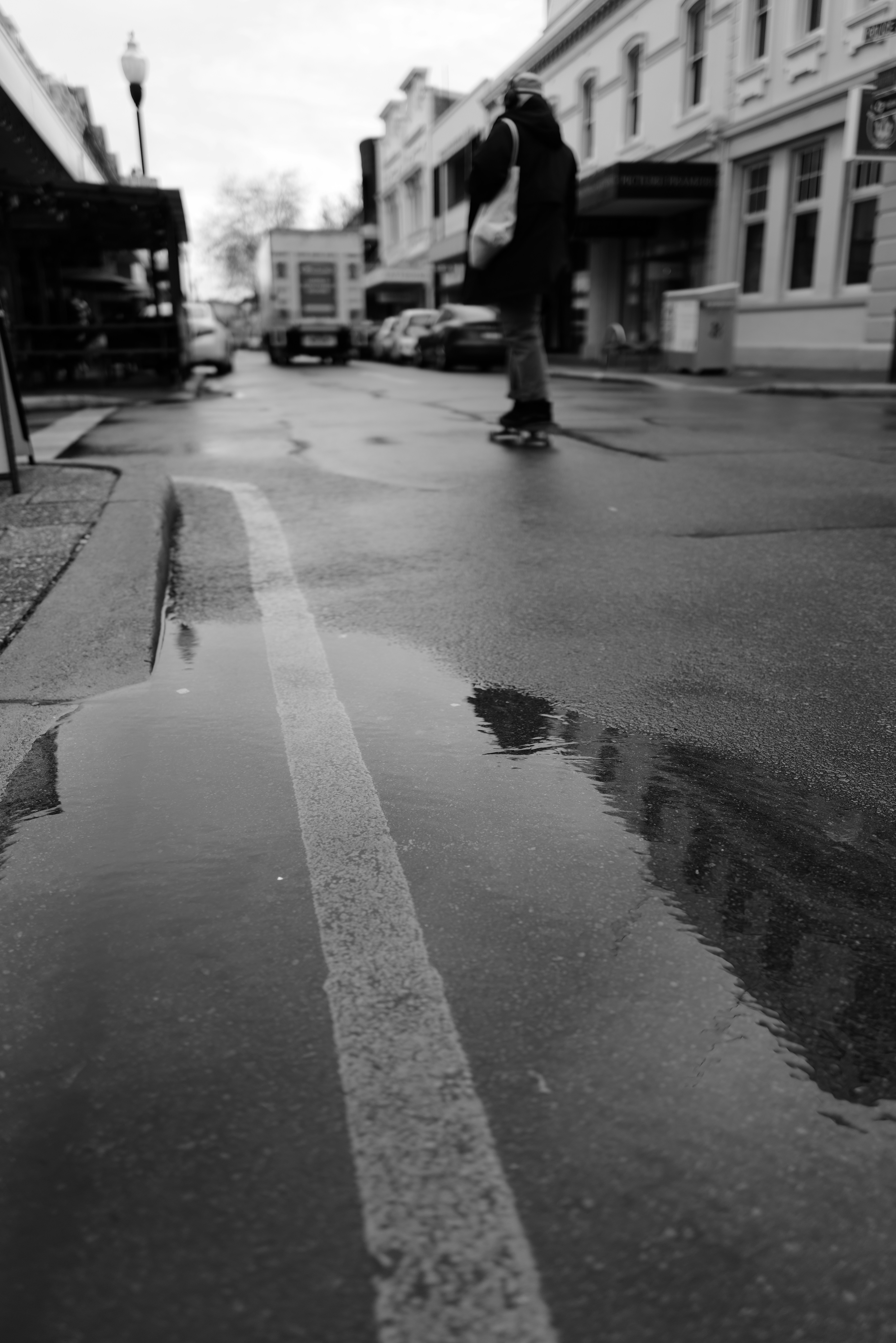 Person on skateboard on wet street after rain