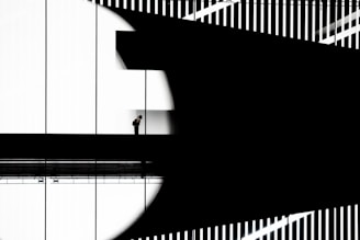 Man standing on walkway with abstract shadows