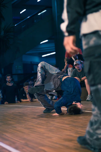 Breakdancer performs a move on a wooden floor.