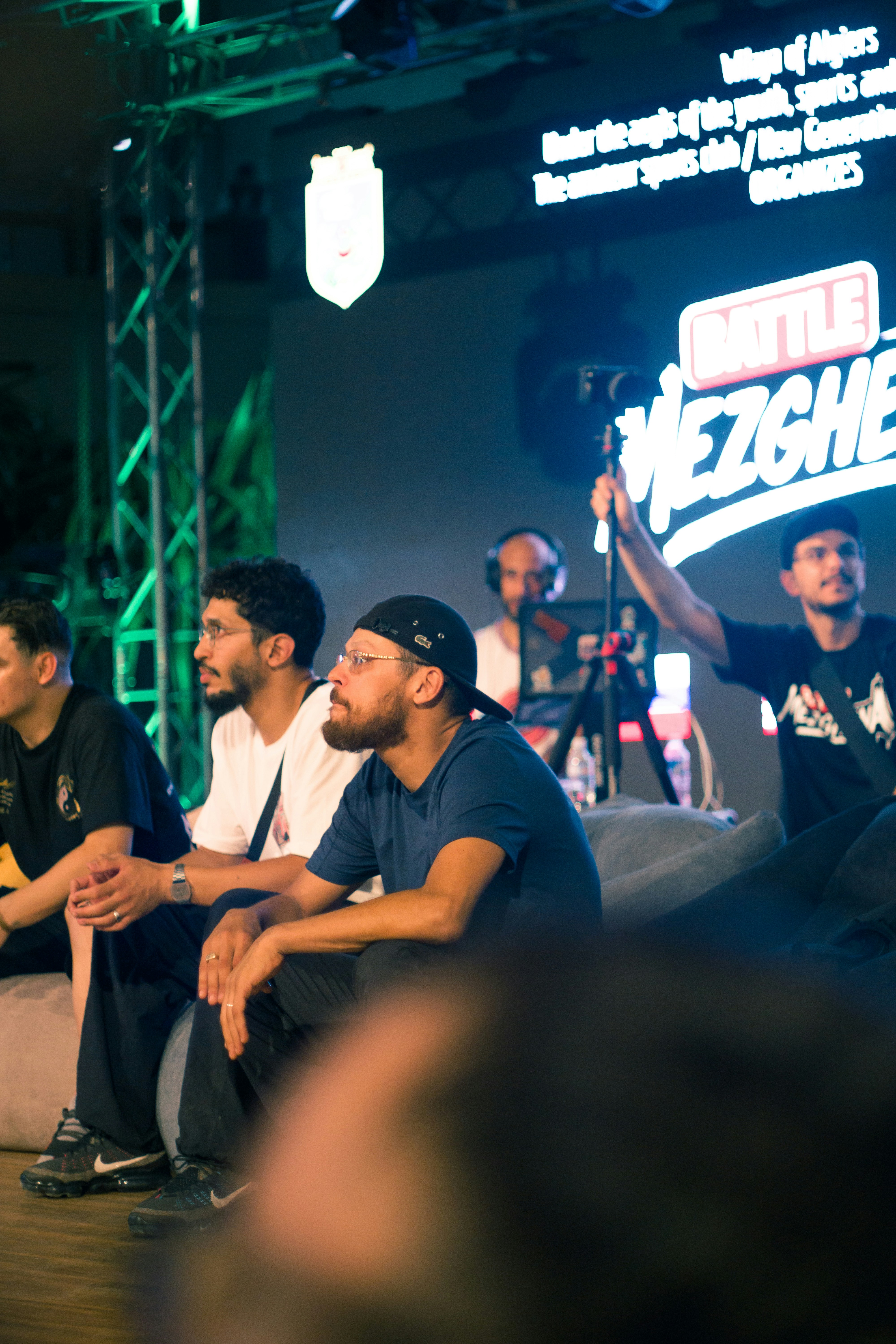 Young men watching an esports competition on a large screen.