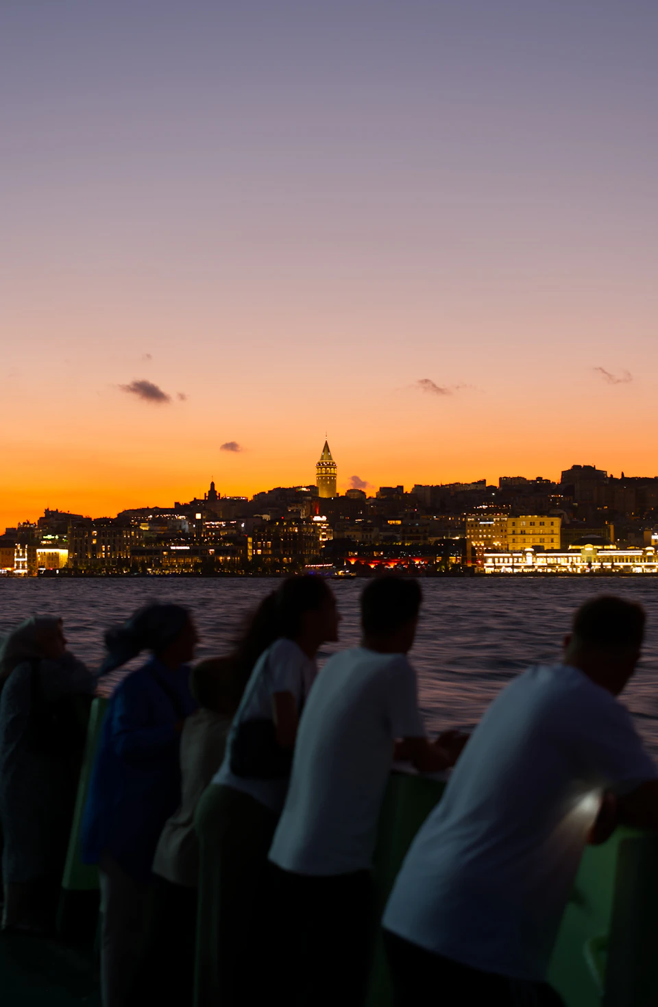 Passengers on a Bosphorus ferry watching the Istanbul skyline at sunset