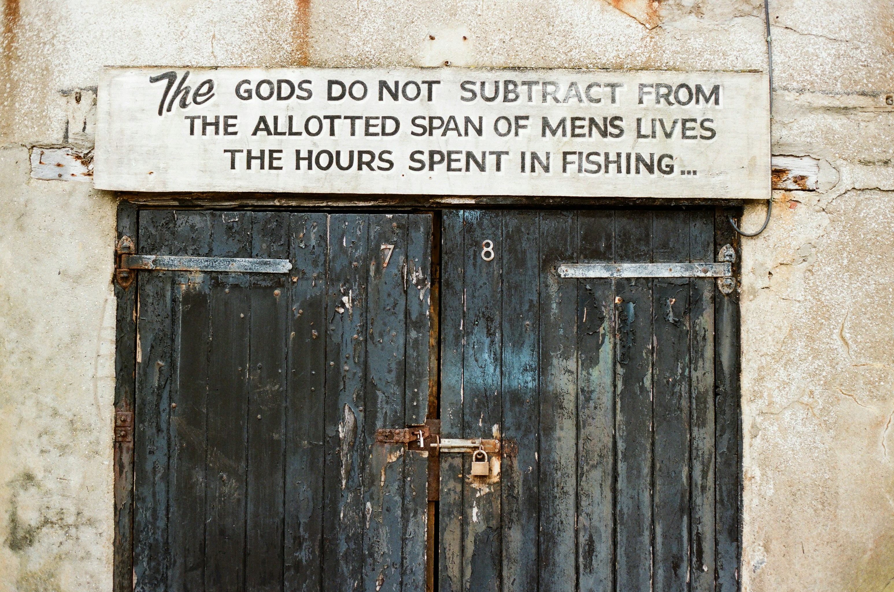 Old wooden doors with quote about fishing.