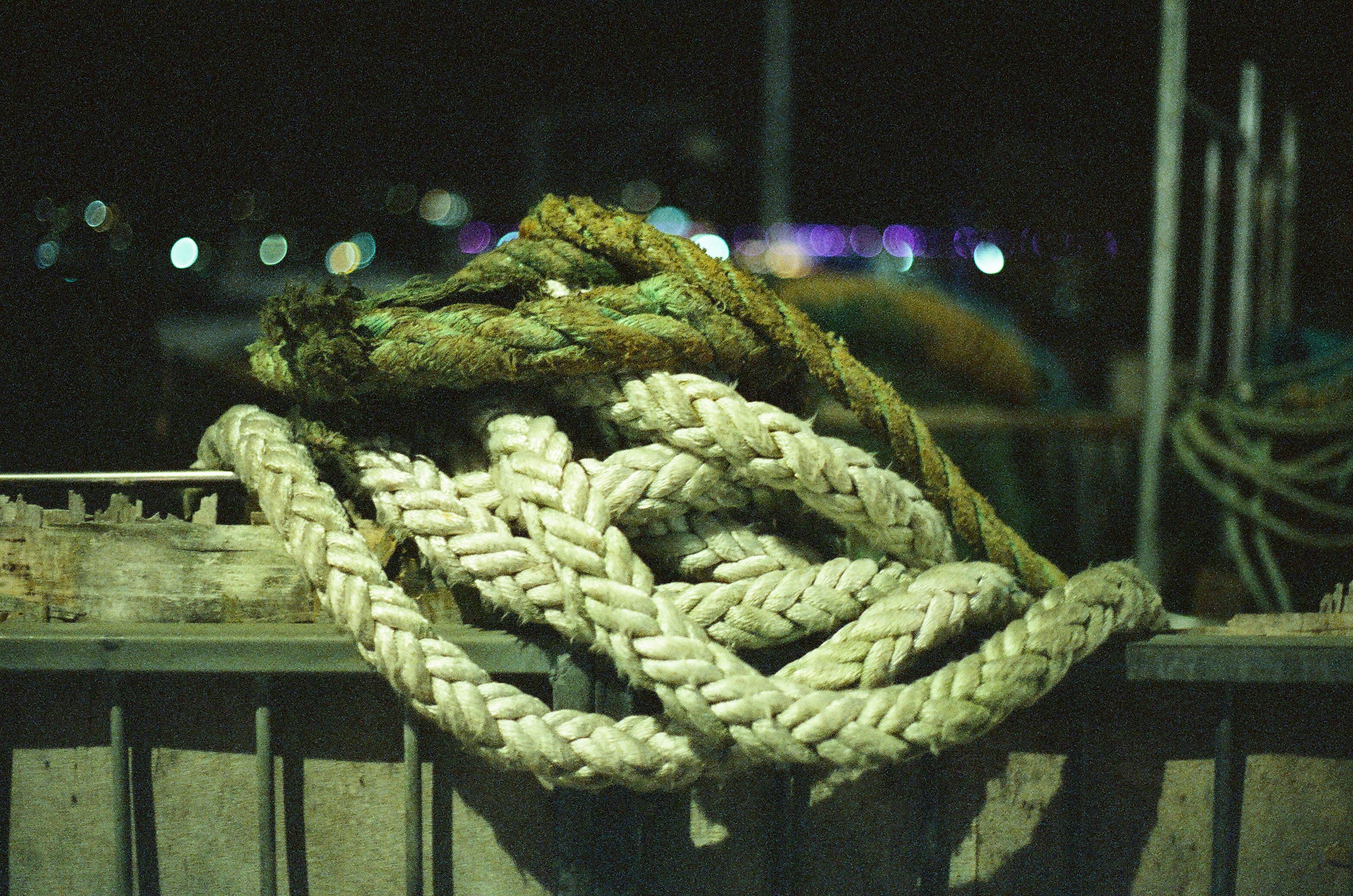 Thick ropes coiled on a fence at night