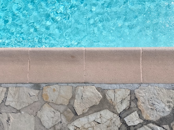 Close-up of pool water meeting the stone edge of a residential pool