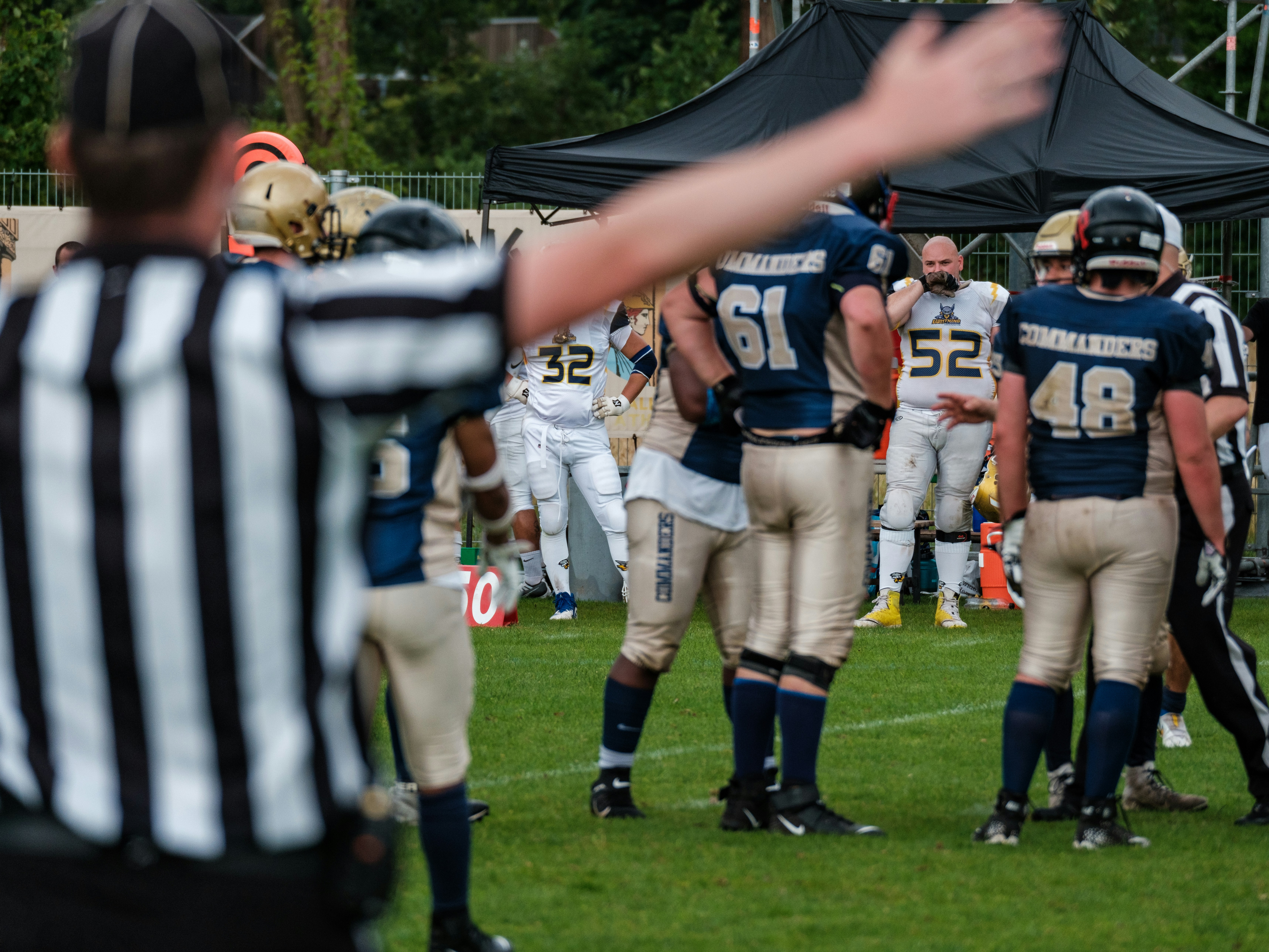 American football players and referee on field