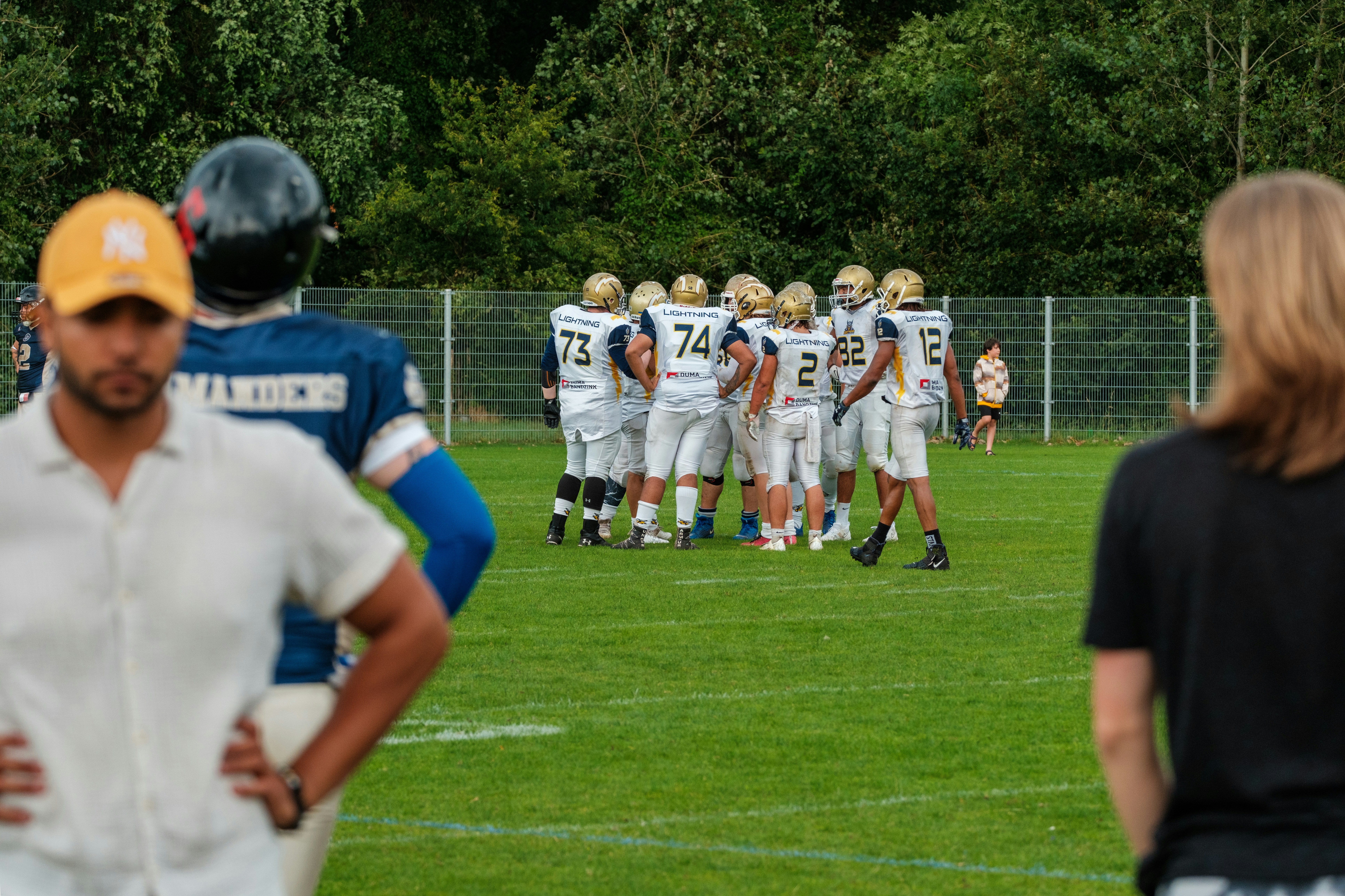 American football team huddles on field