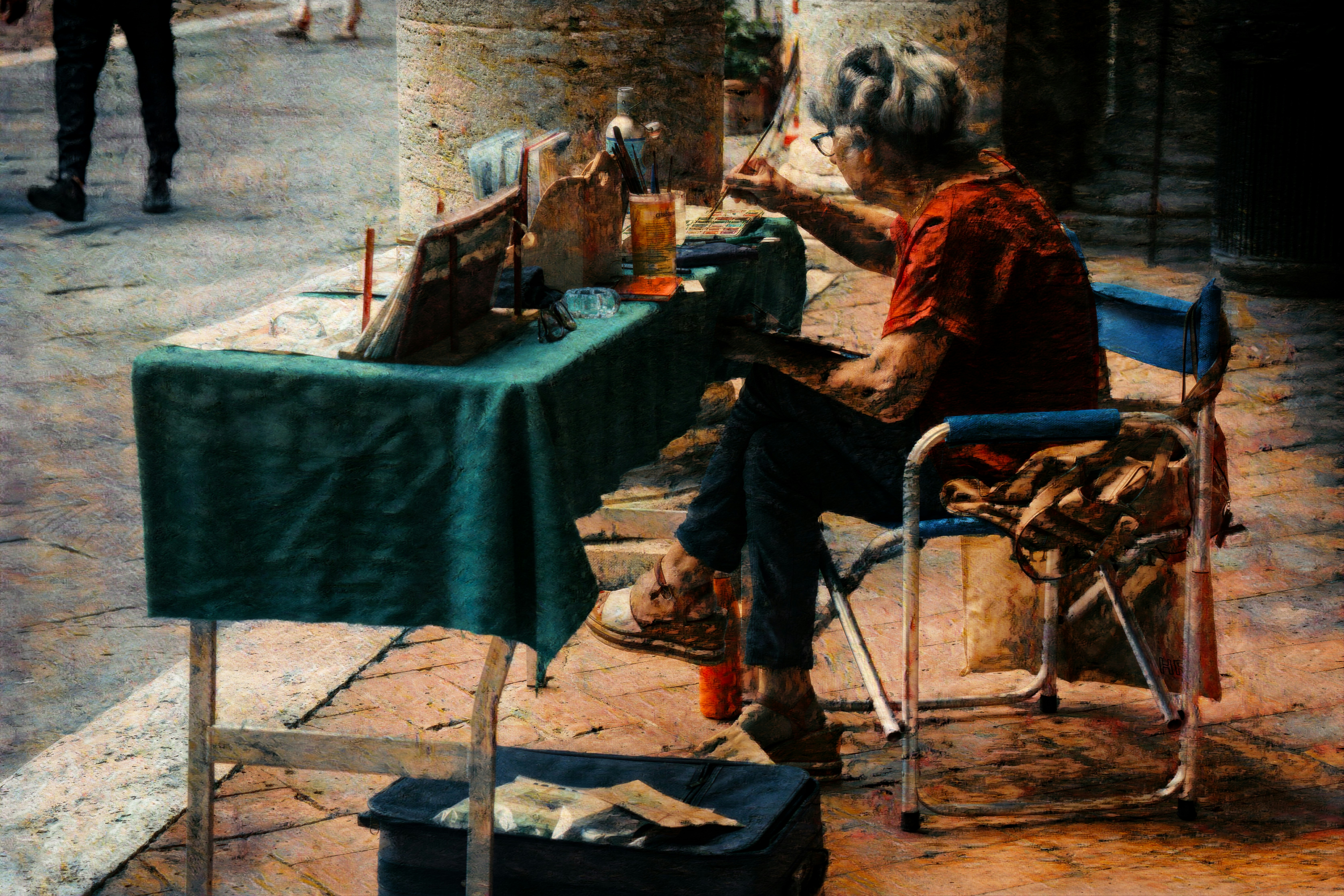 Elderly woman sitting at a table selling crafts.