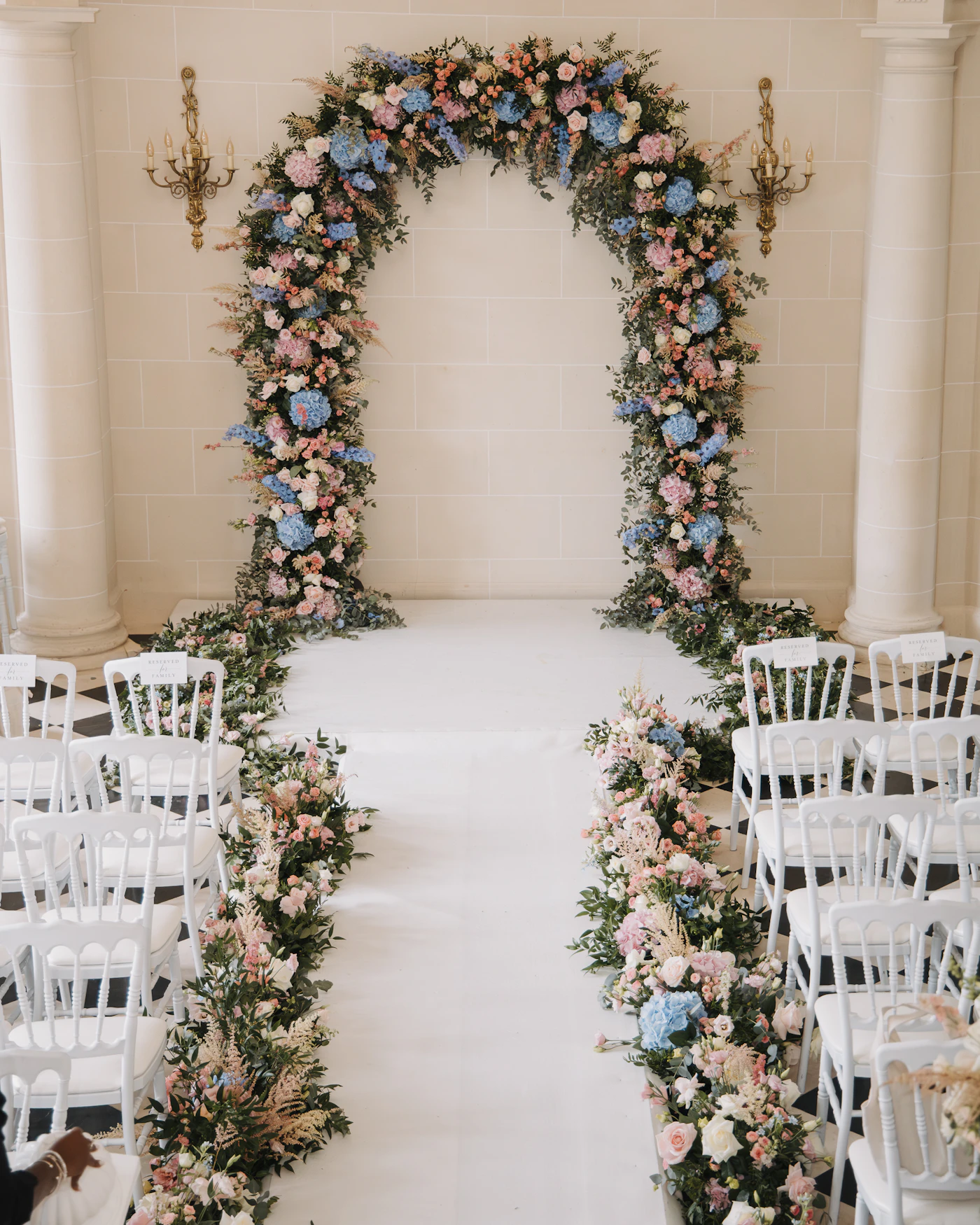 How to repurpose ceremony flowers for reception decor — Bridesmaid bouquets displayed in glass vases along a sweetheart table