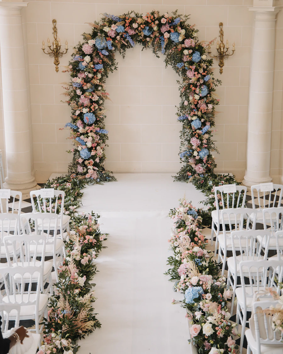 Floral arch styled over a wedding aisle