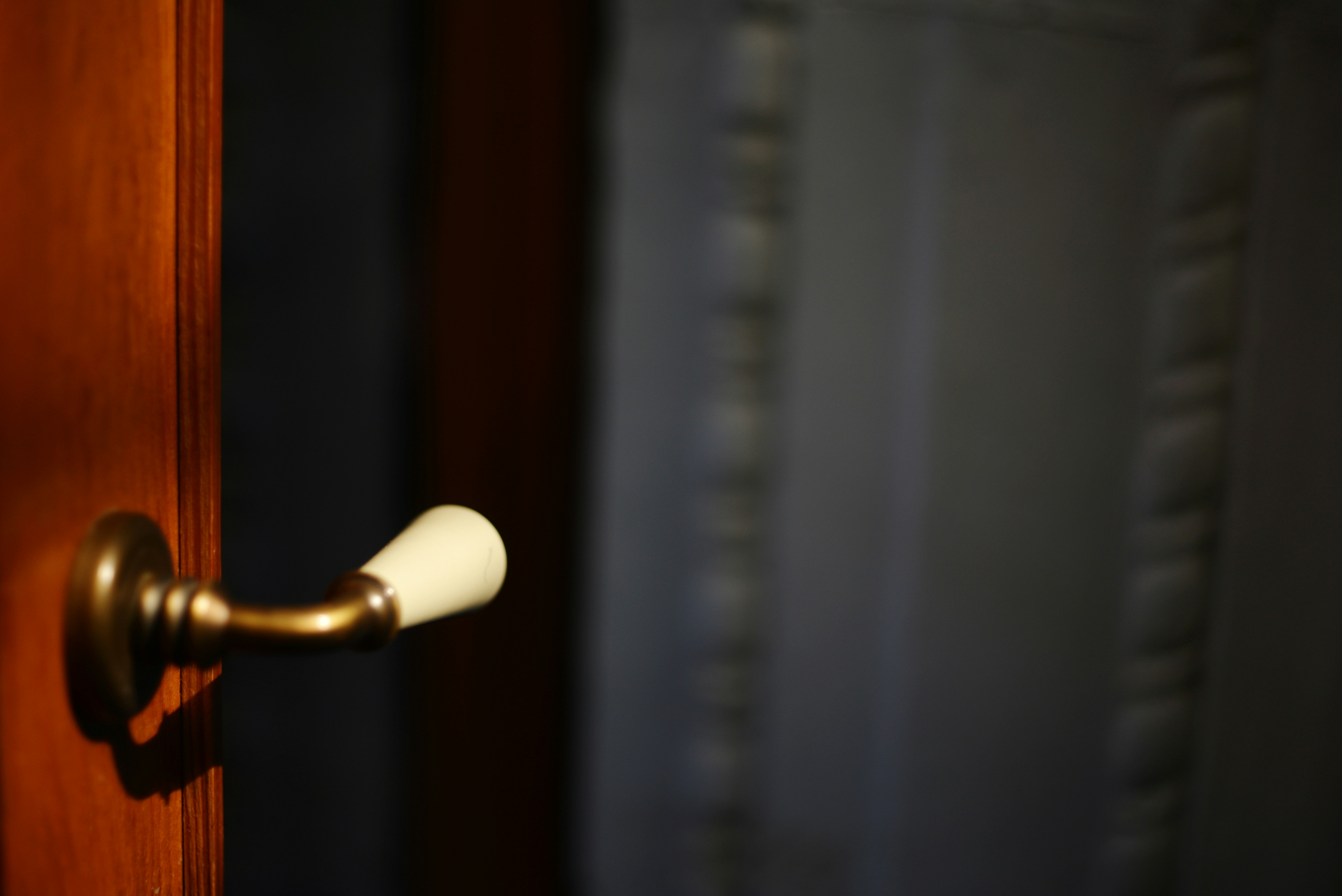 A wooden door with a vintage doorknob slightly ajar