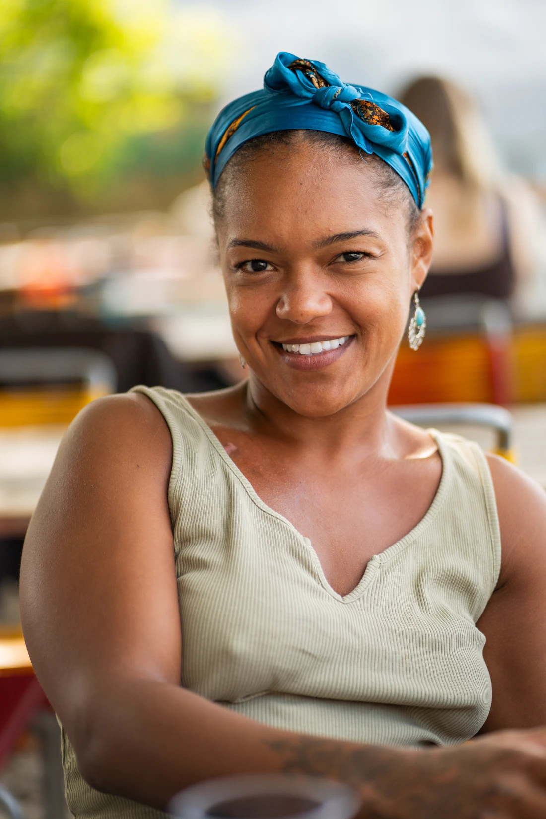 Mulher sorrindo com lenço azul no cabelo