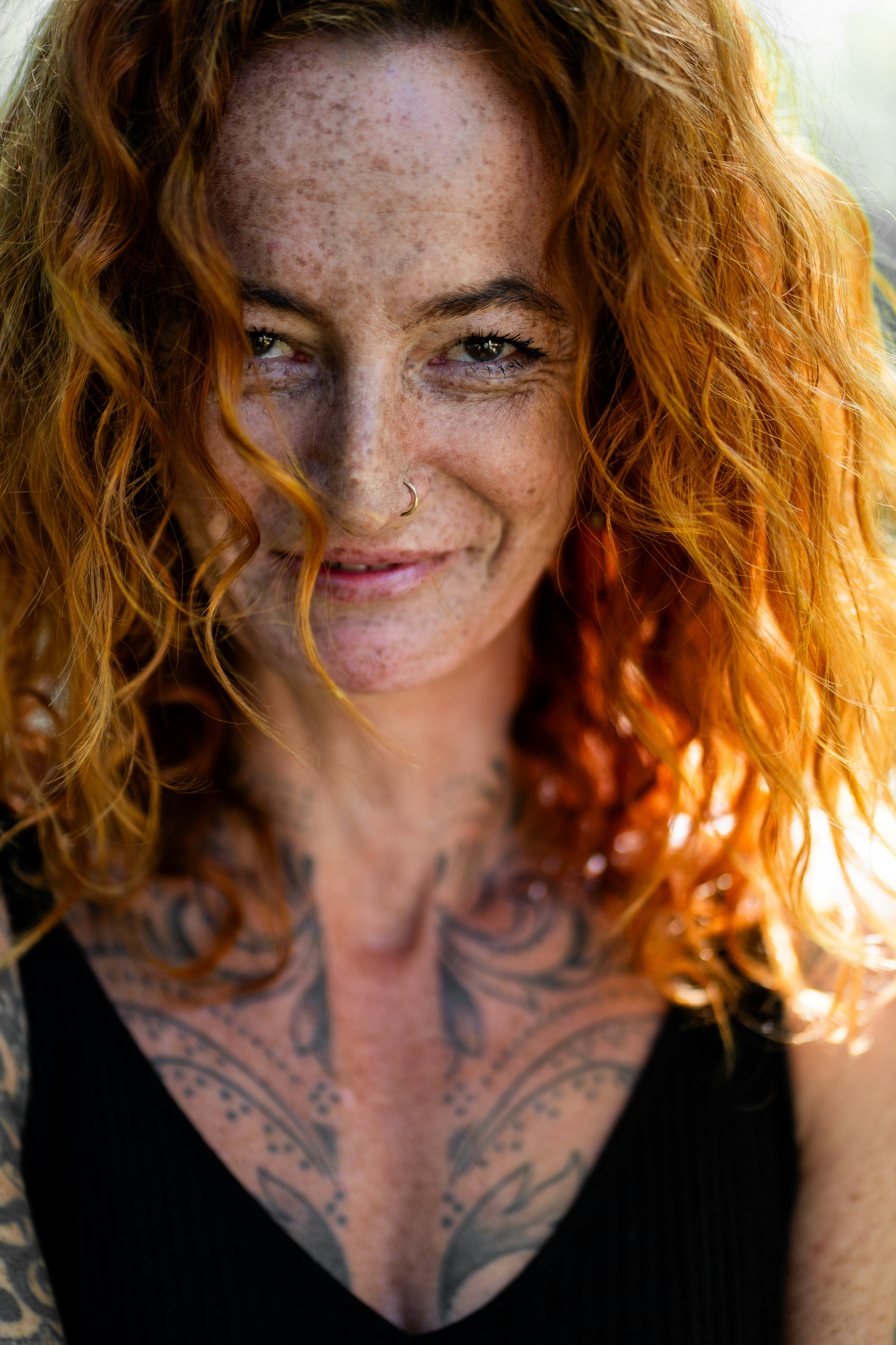 Woman with red curly hair and freckles smiling