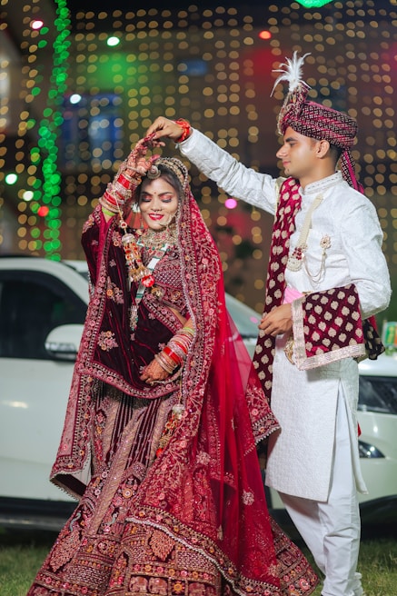 Newlyweds in traditional indian wedding attire dancing together.