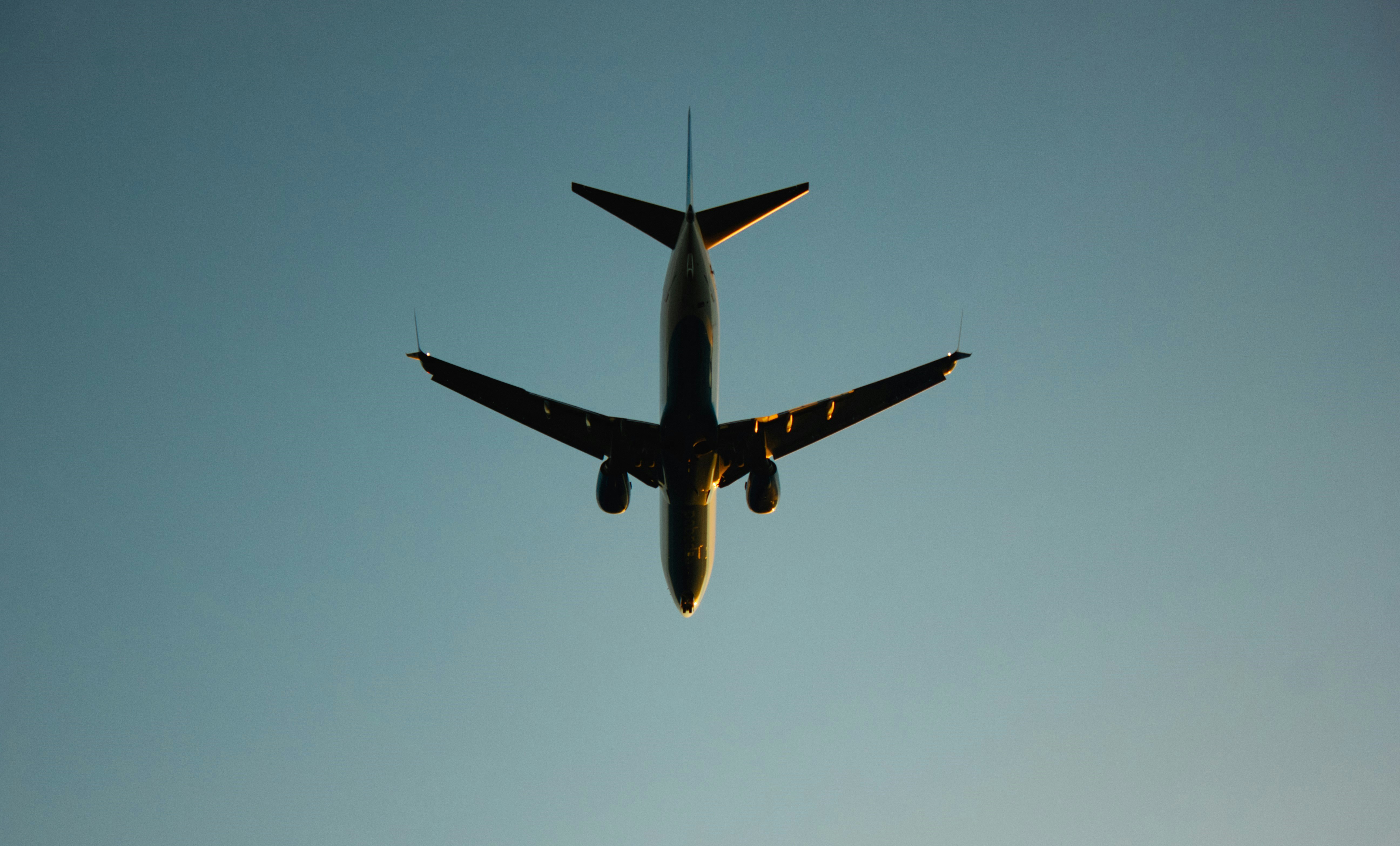 Airplane flying overhead against a clear blue sky.